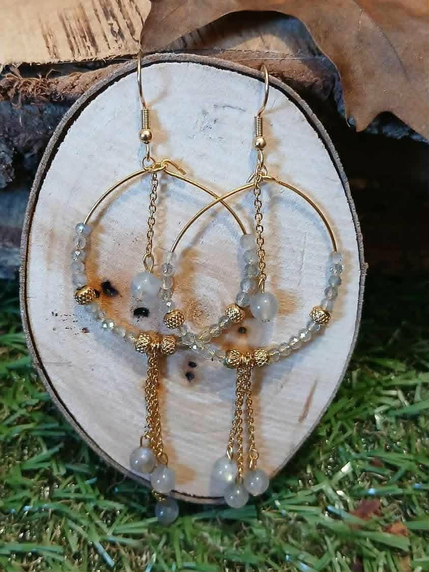 Création Magic Gaïa, créoles labradorite dorées posées sur bois clair, perles grises et chaînes fines pour intuition et éclat solaire.
