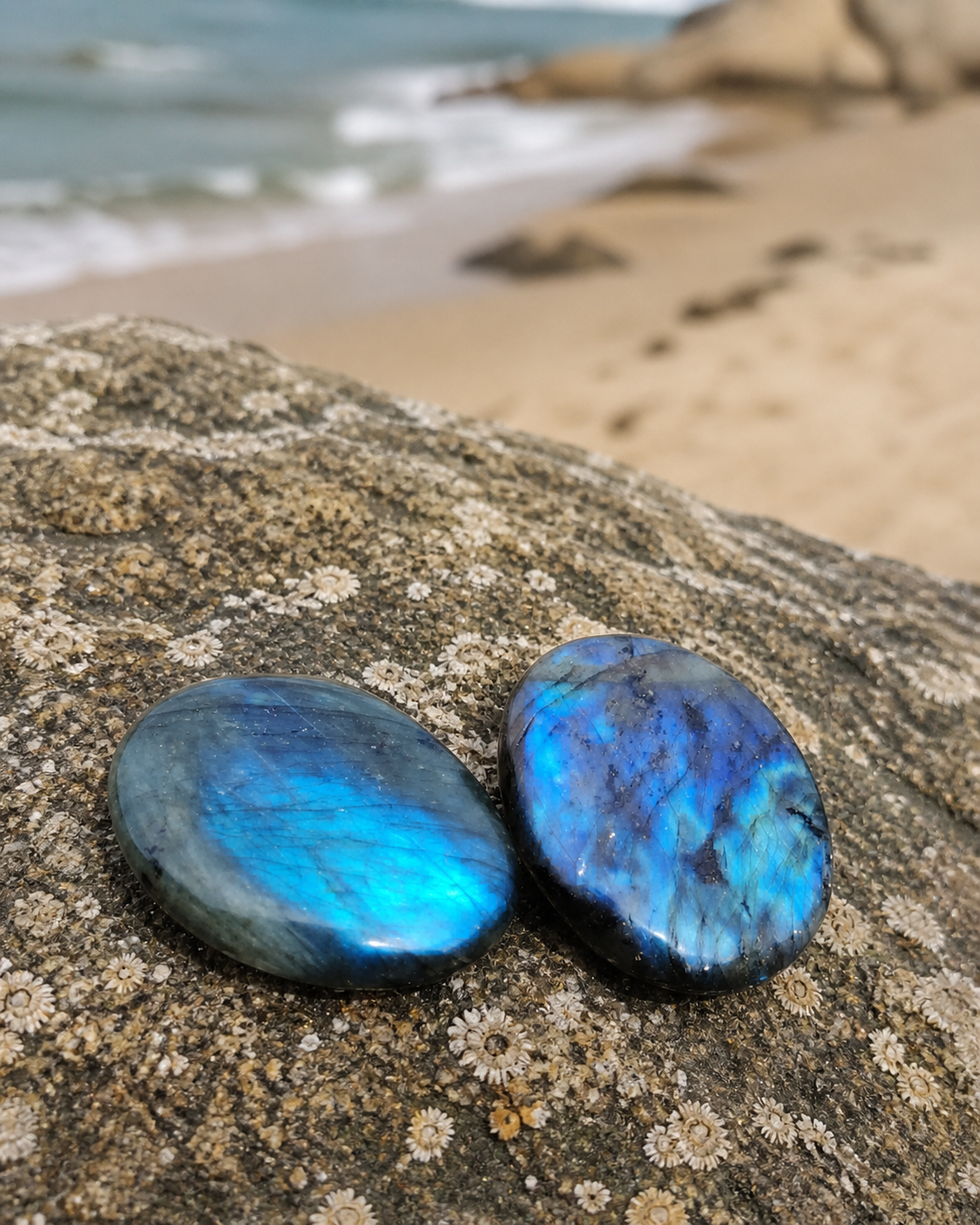 Deux galets de labradorite polie en décor naturel, reflets bleus et turquoise pour intuition, clarté et protection symbolique.