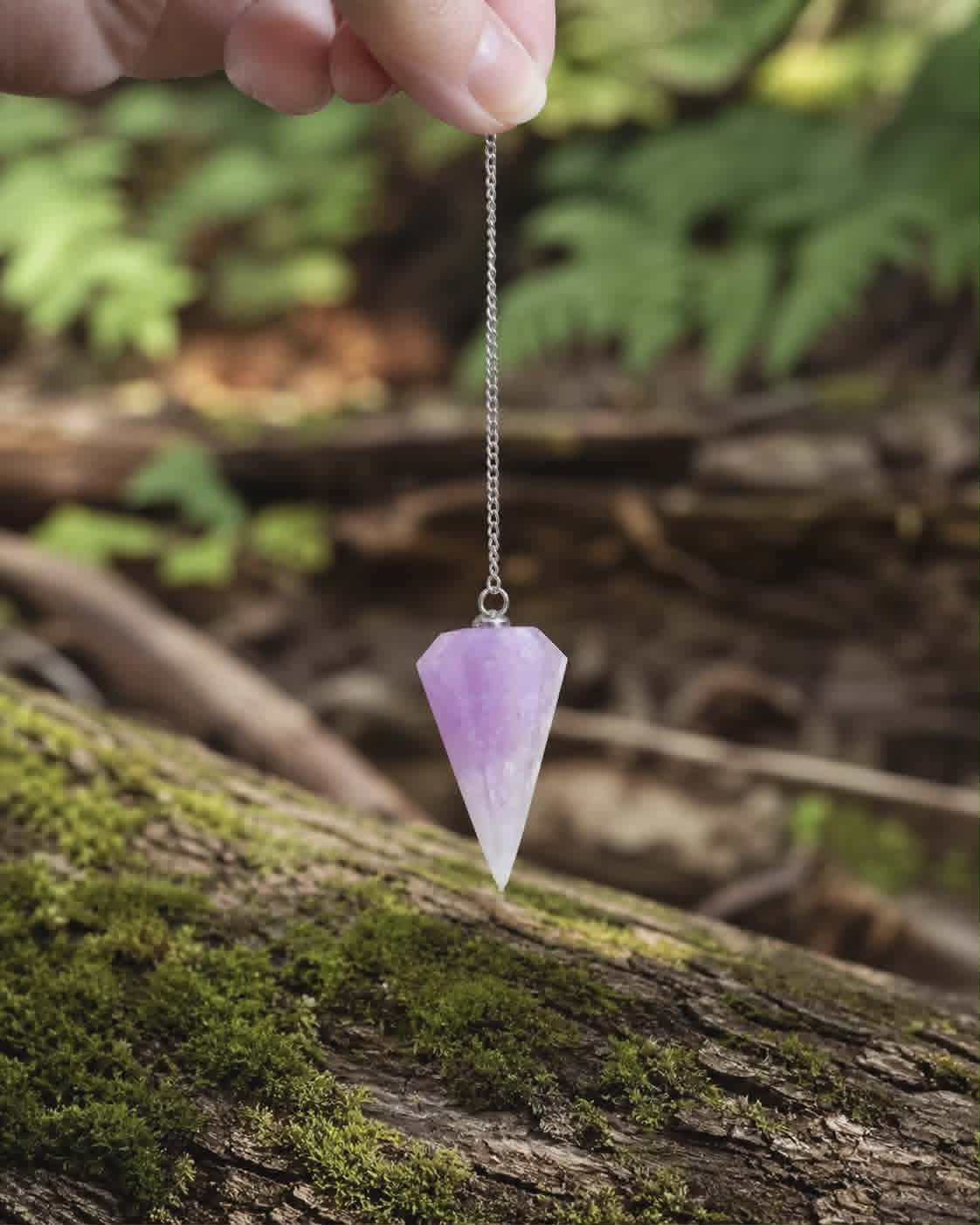 Pendule Améthyste suspendu en main dans un décor forestier, outil spirituel pour guidance et perception subtile.