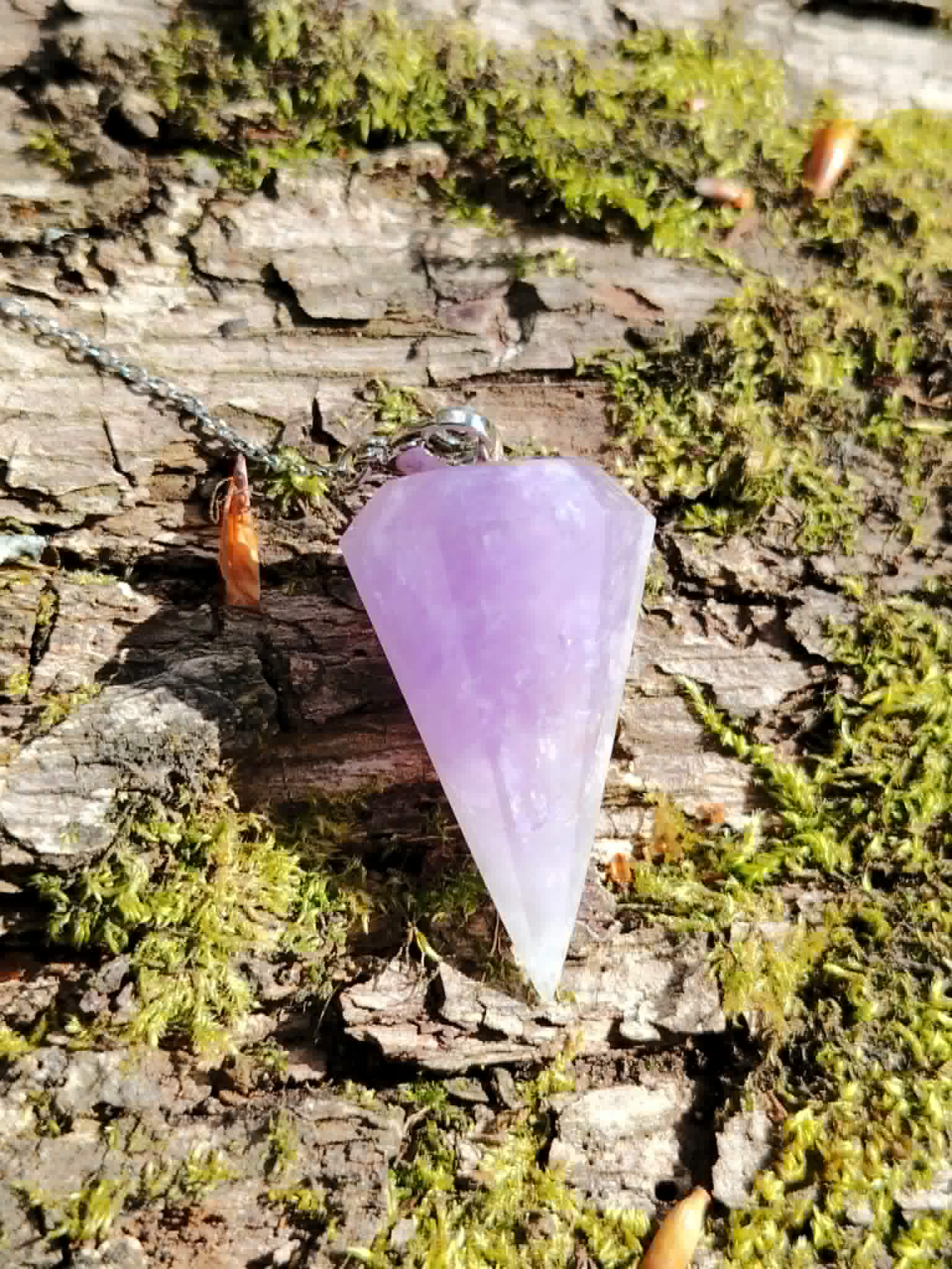 Pendule en Améthyste sur écorce moussue, pierre lilas lumineuse pour méditation, sérénité et écoute intuitive.