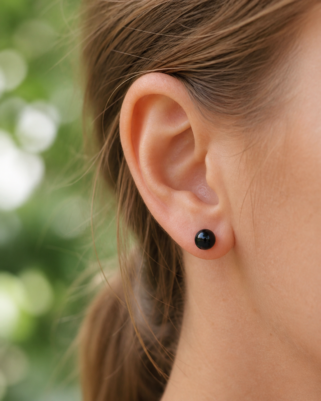 Boucle d’oreille puce Obsidienne noire 6 mm portée à l’oreille, bijou discret en inox 304 pour stabilité et force intérieure.