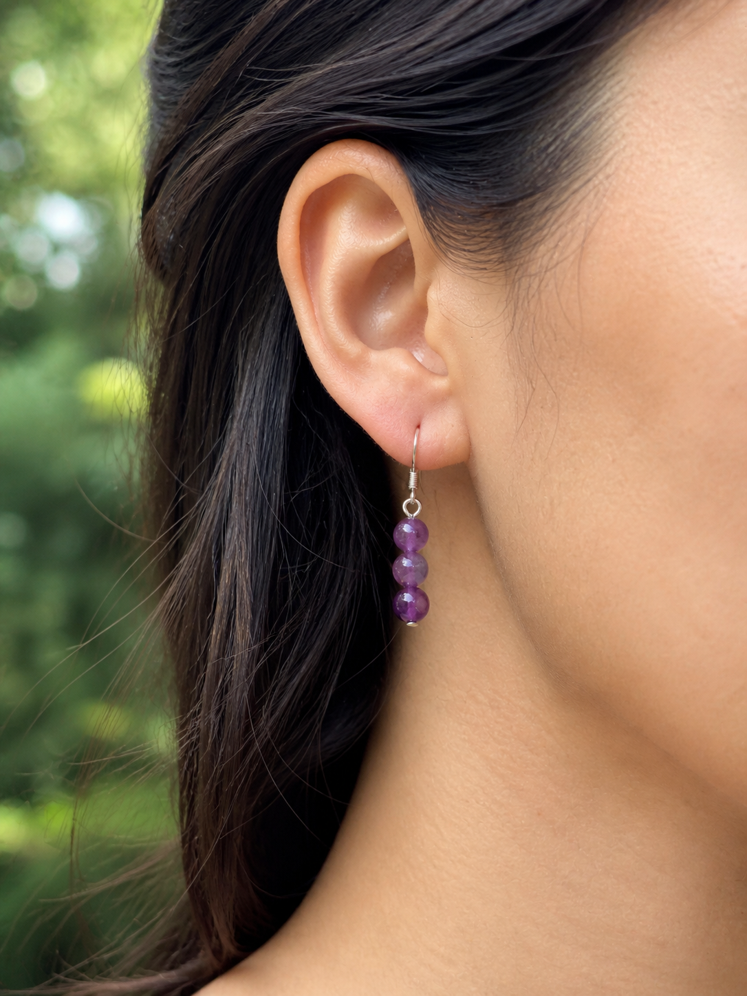 Boucles d’oreilles Améthyste portées à l’oreille, création Magic Gaïa en inox avec perles violettes pour intuition et calme.