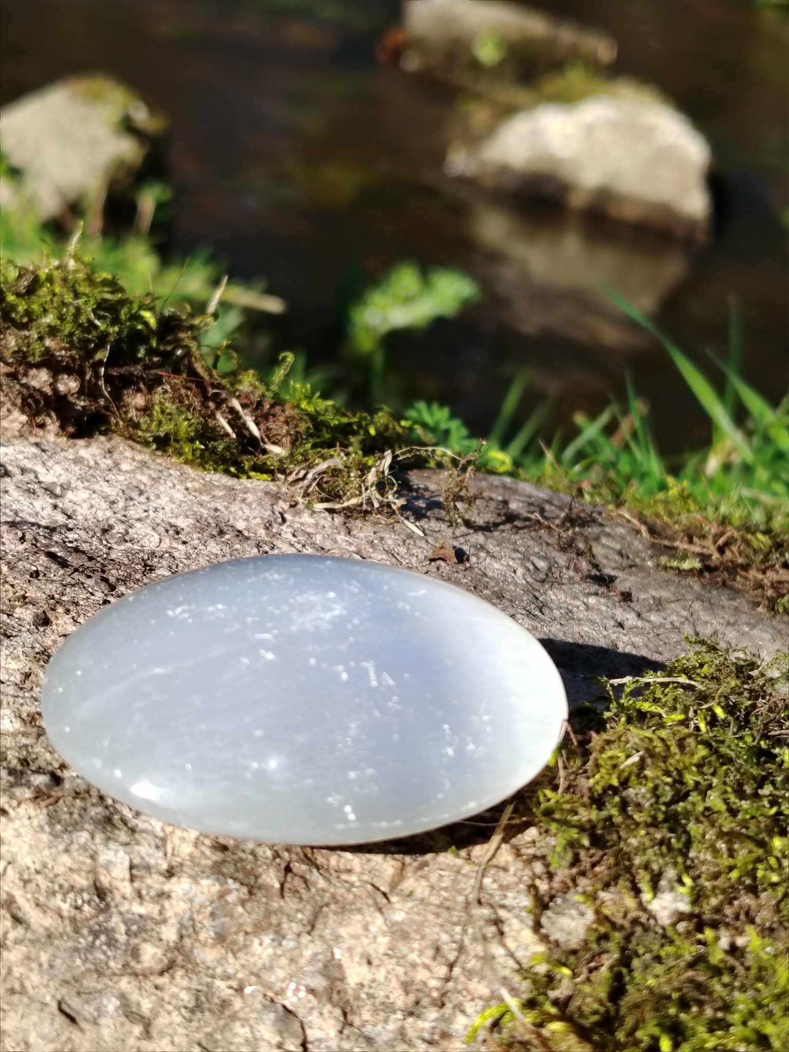 Sélénite polie en décor de mousse et d’eau, pierre blanche aux reflets soyeux pour ambiance bien-être et purification symbolique.