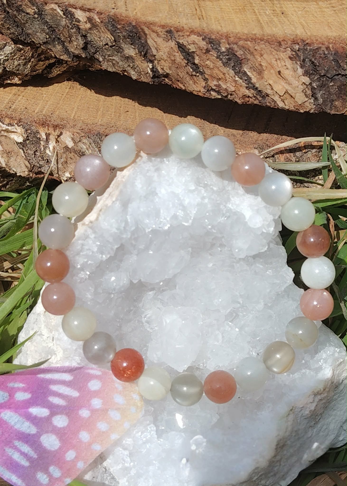 Bracelet Pierre de Lune beige multicolore autour d’une géode blanche, perles rosées, crème et grises associées à l’apaisement émotionnel.