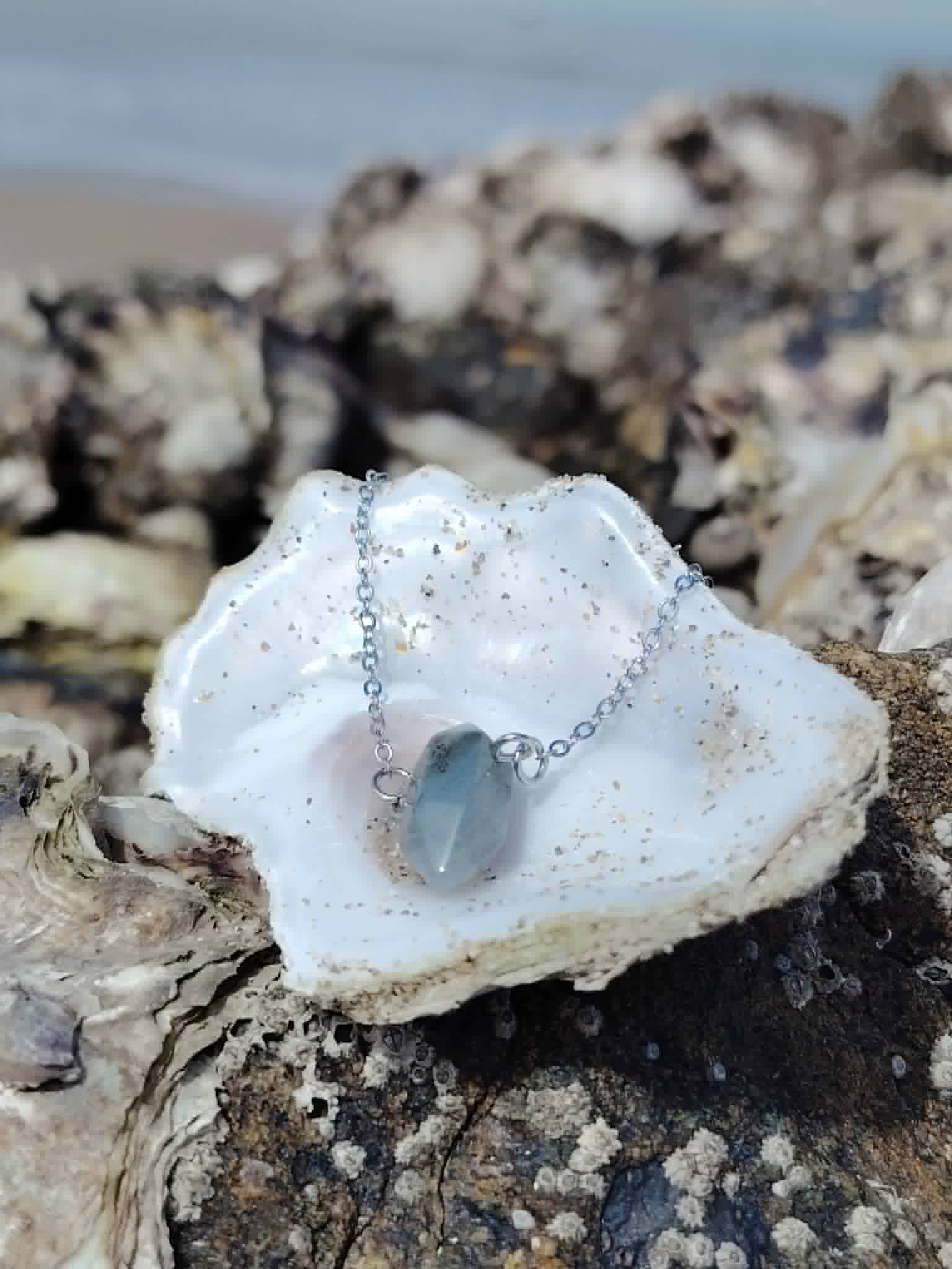 Pendentif pointe Labradorite dans une coquille en bord de mer, bijou naturel en acier inoxydable pour intuition et préservation énergétique.