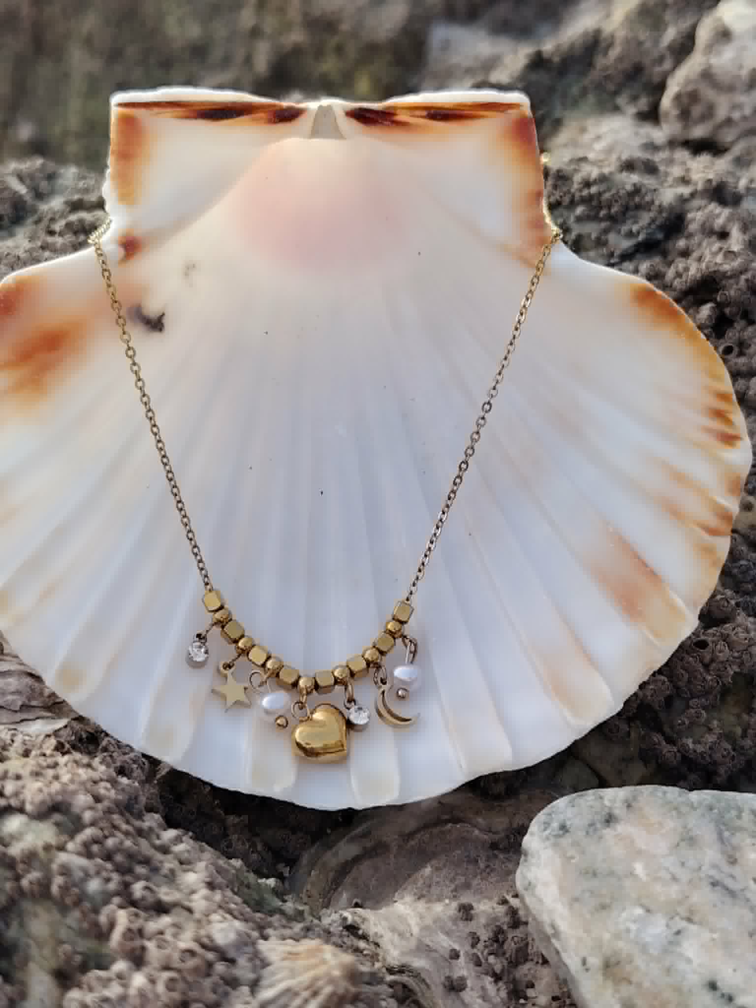 Collier doré cœur lune étoile sur coquillage entouré de rochers, bijou lumineux en acier inoxydable au style poétique et délicat.