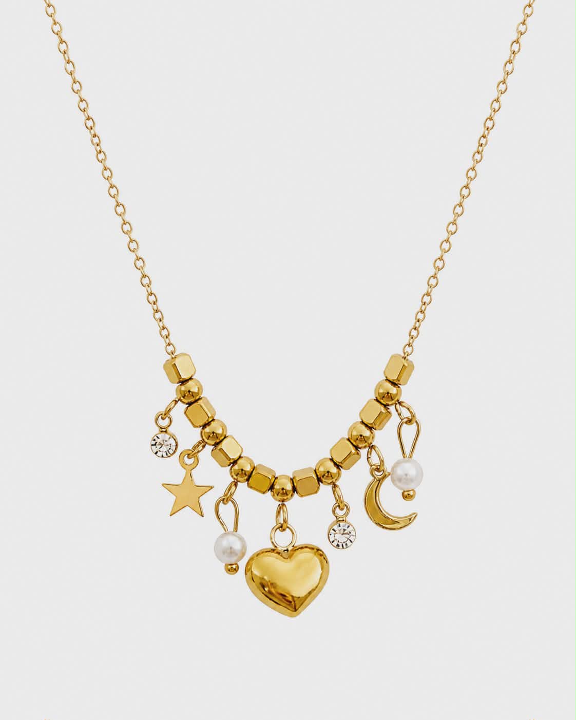 Collier doré cœur lune étoile détouré sur fond blanc, chaîne fine en acier inoxydable avec breloques célestes et cœur central brillant.