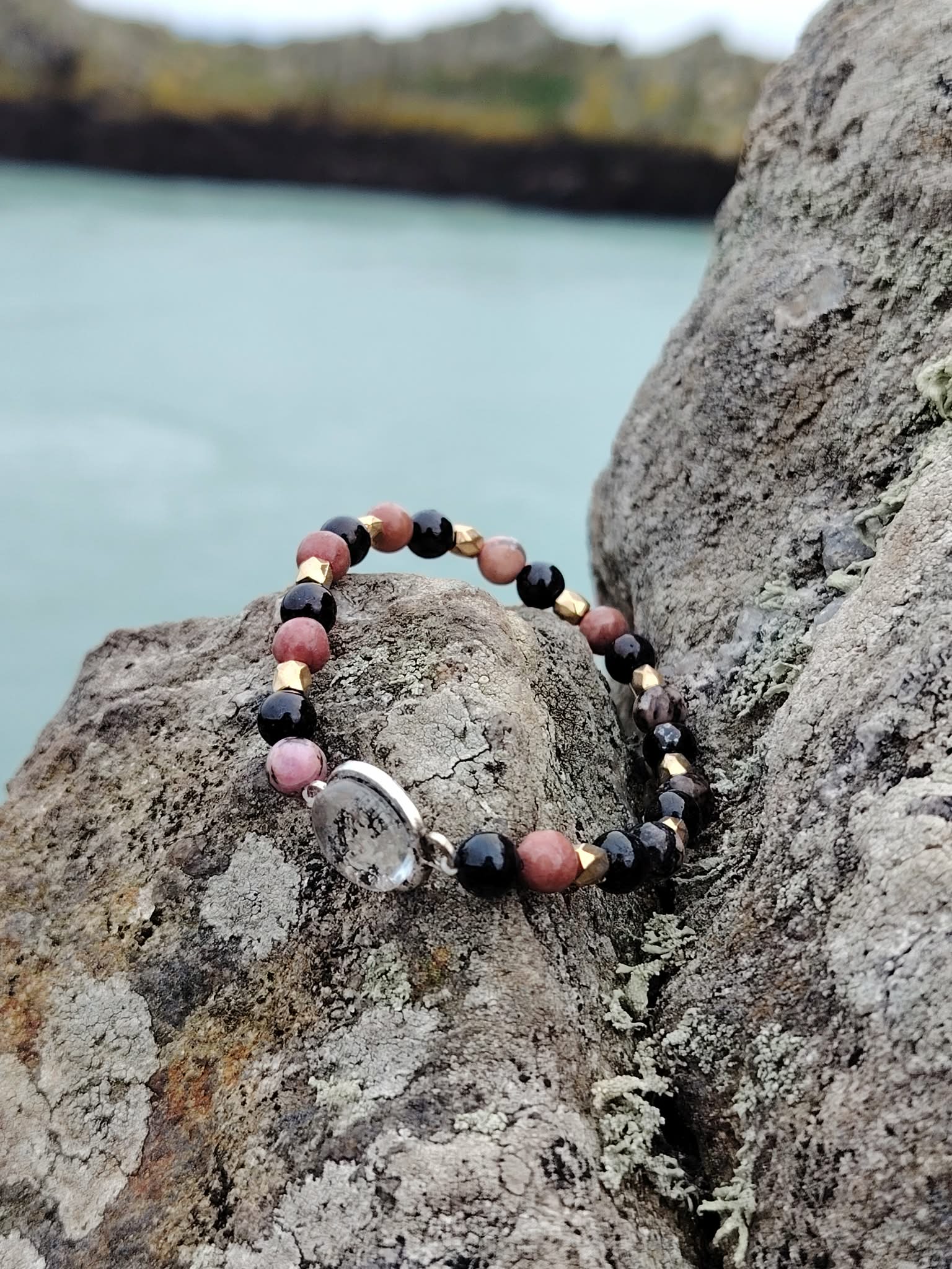 Bracelet création Magic Gaïa en Rhodonite et Tourmaline Noire, cabochon rond argenté et perles dorées sur montage élastique.