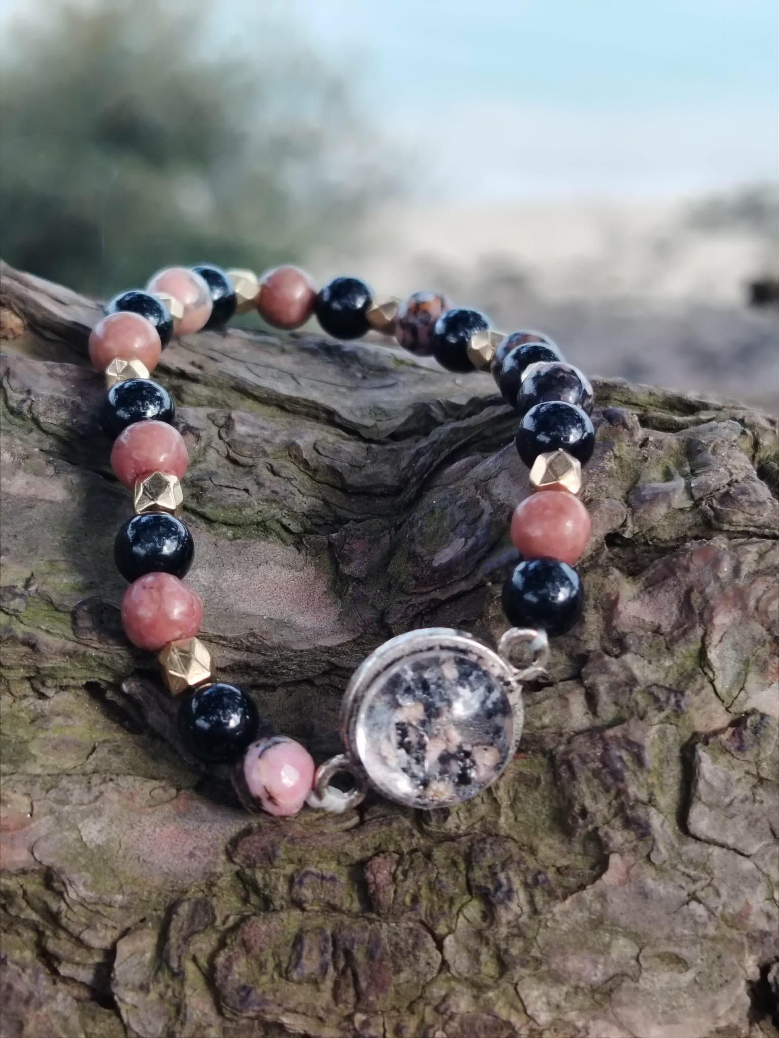 Bracelet Rhodonite et Tourmaline Noire création Magic Gaïa sur écorce, perles roses et noires avec cabochon central argenté.