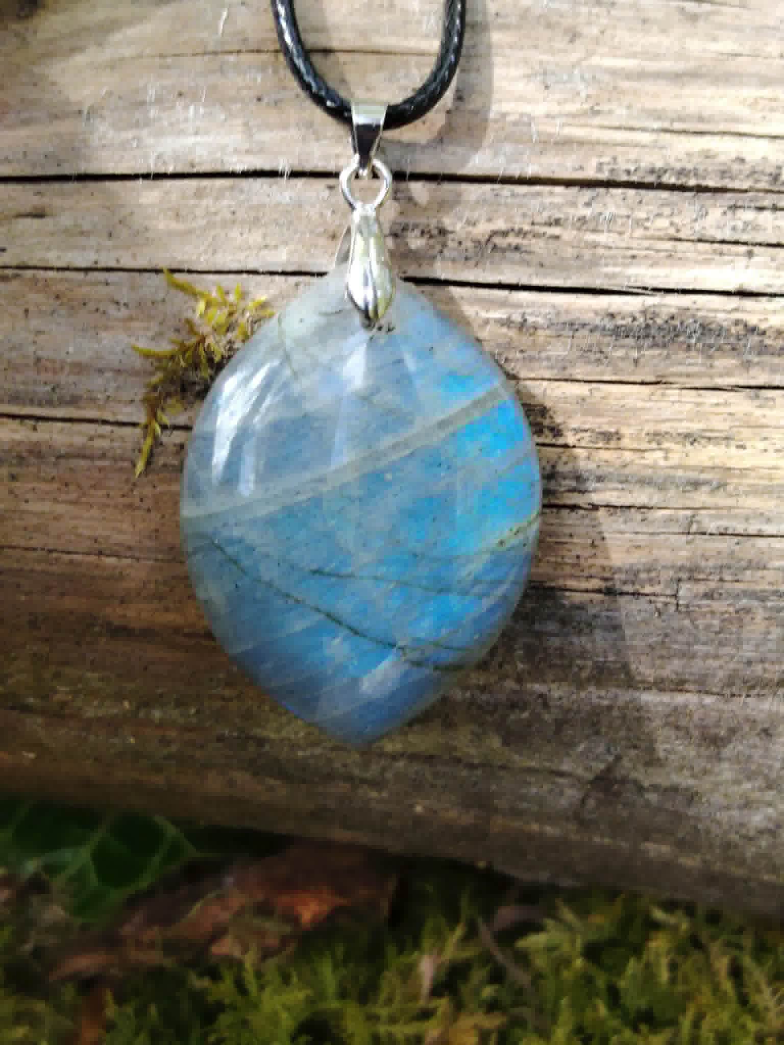 Pendentif labradorite marquise posé sur bois clair, nuances bleu pâle et gris minéral dans une ambiance forêt bretonne.