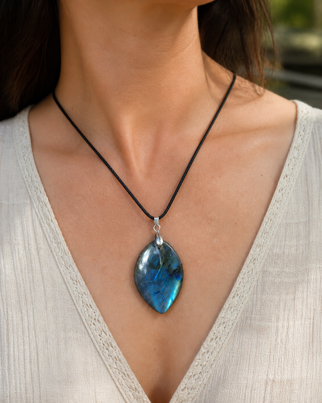Pendentif labradorite marquise porté sur cordon noir, reflets bleus lumineux au creux du cou pour une allure naturelle.