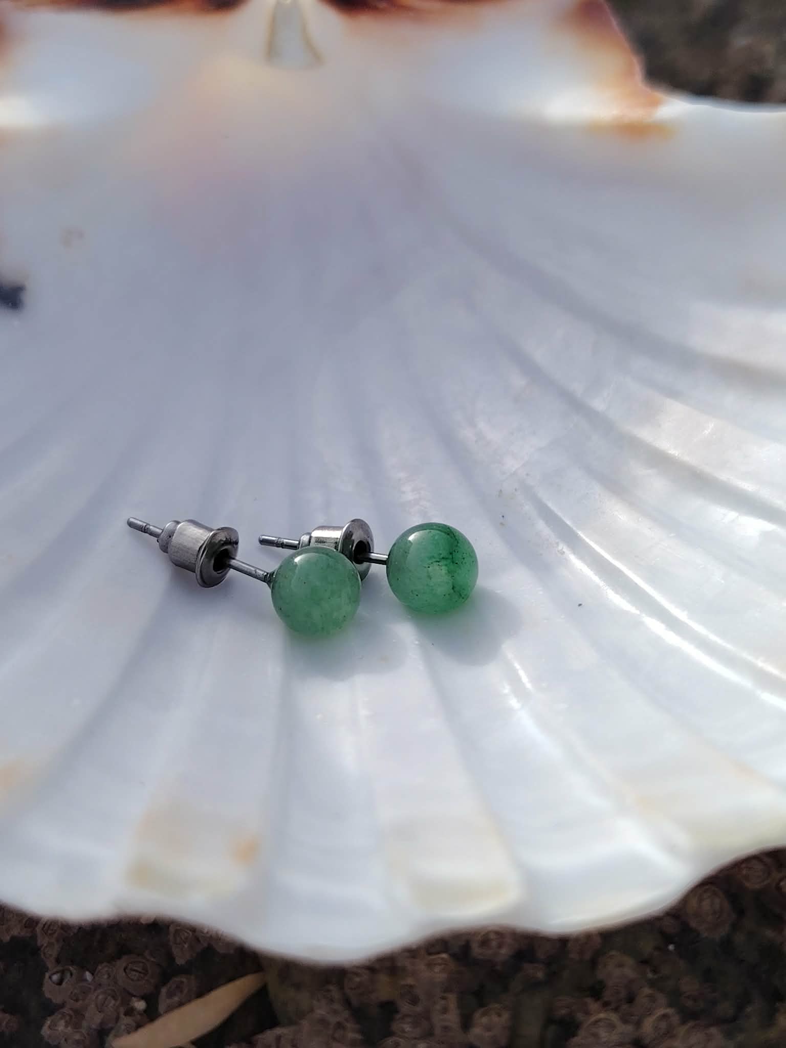 Puces Aventurine Verte 6 mm présentées sur coquille blanche, bijou en pierre naturelle associé au calme intérieur.