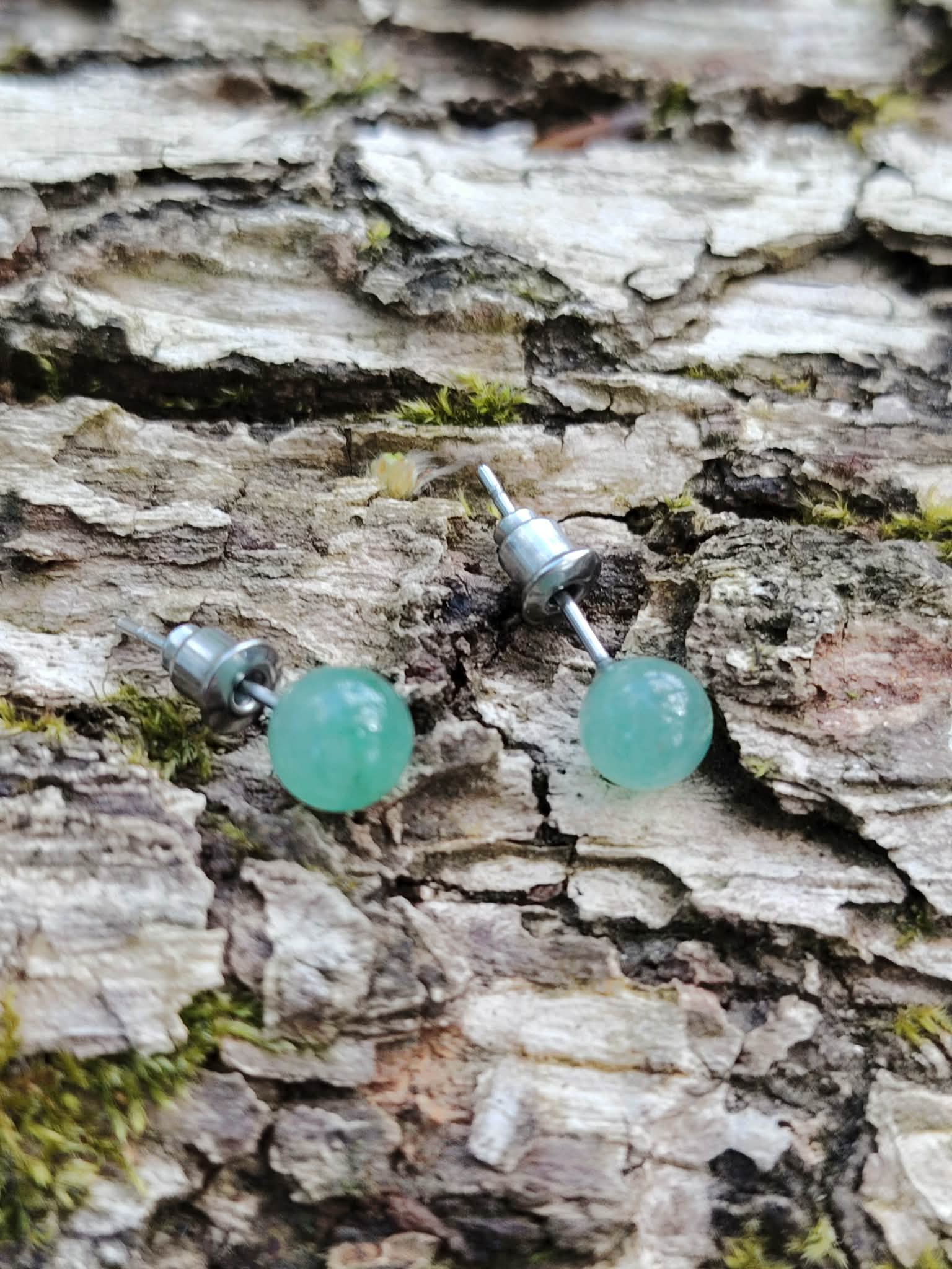 Boucles d’oreilles puces Aventurine Verte 6 mm posées sur écorce moussue en Bretagne, bijou frais en inox 304.