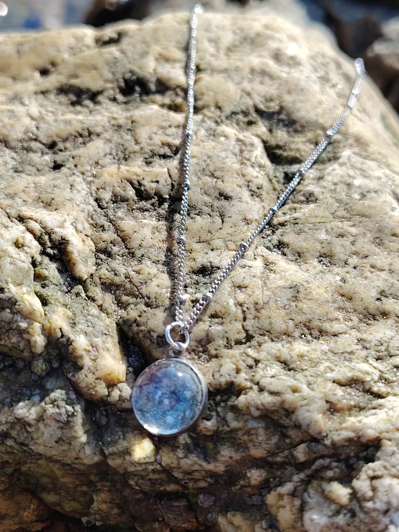 Collier cabochon Apatite en paillettes sur décor clair, bijou bleu argenté délicat pour une tenue élégante.