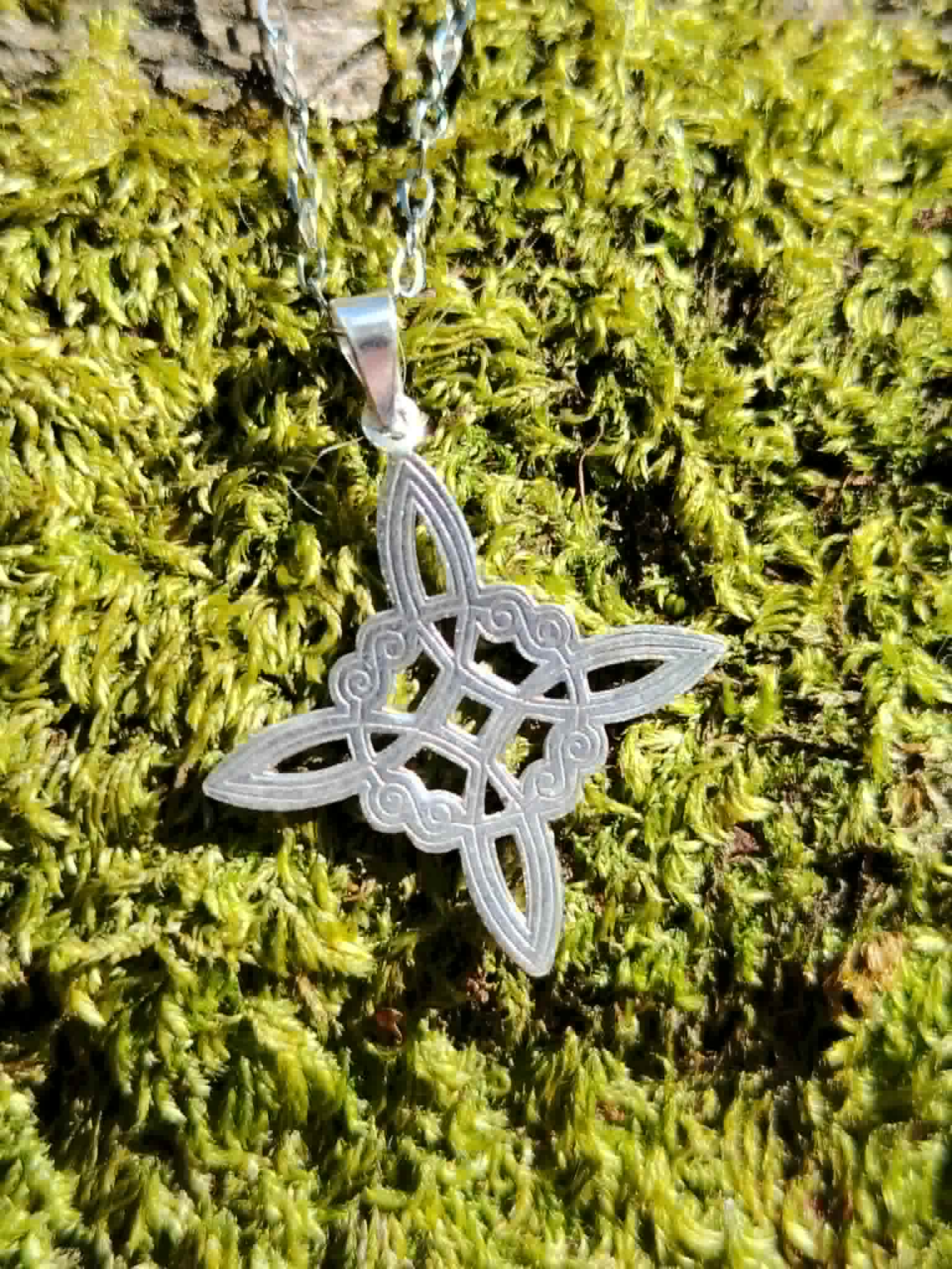 Nœud de Sorcière argent 925 sur mousse verte, pendentif fin et ajouré associé à la protection symbolique.