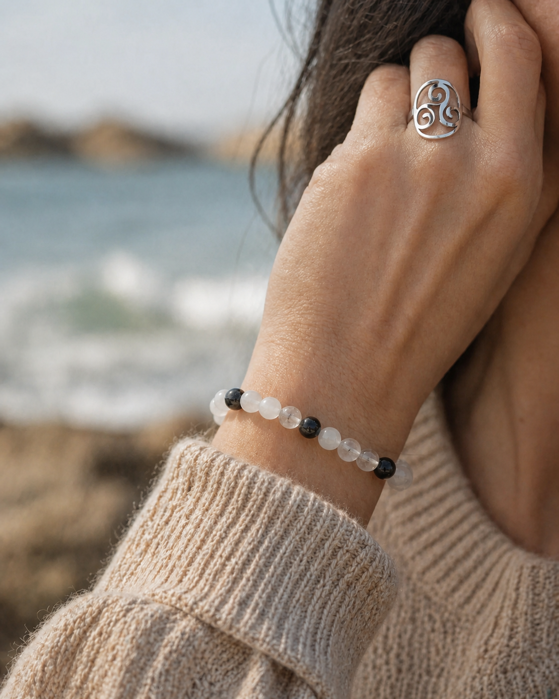Bracelet tourmaline noire et quartz tourmaliné porté en bord de mer en Bretagne, avec bague Triskell argentée pour protection et équilibre.
