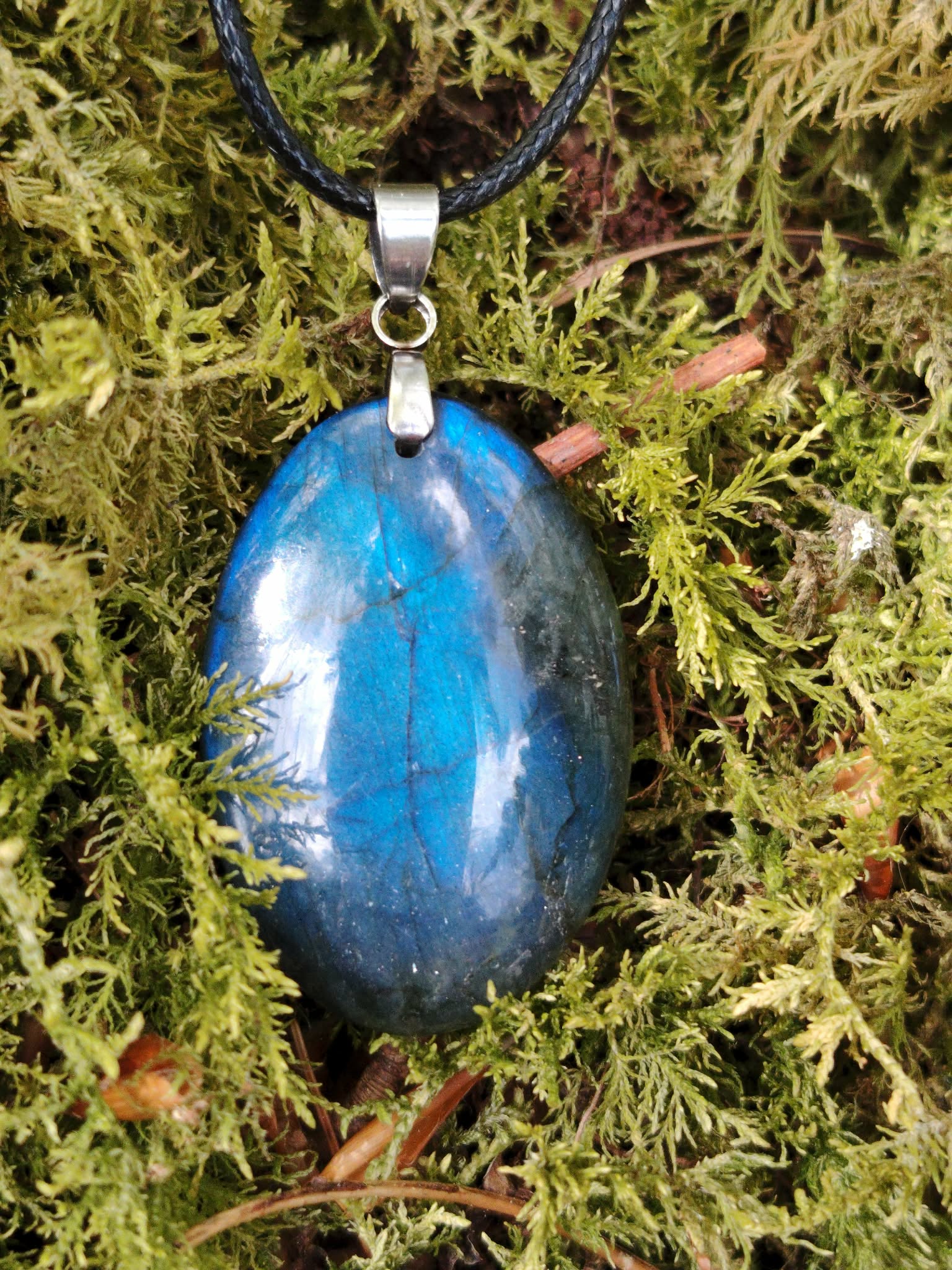 Pendentif Labradorite bleue en pierre naturelle, forme ovale polie avec reflets profonds, monté sur cordon noir pour un style sobre.