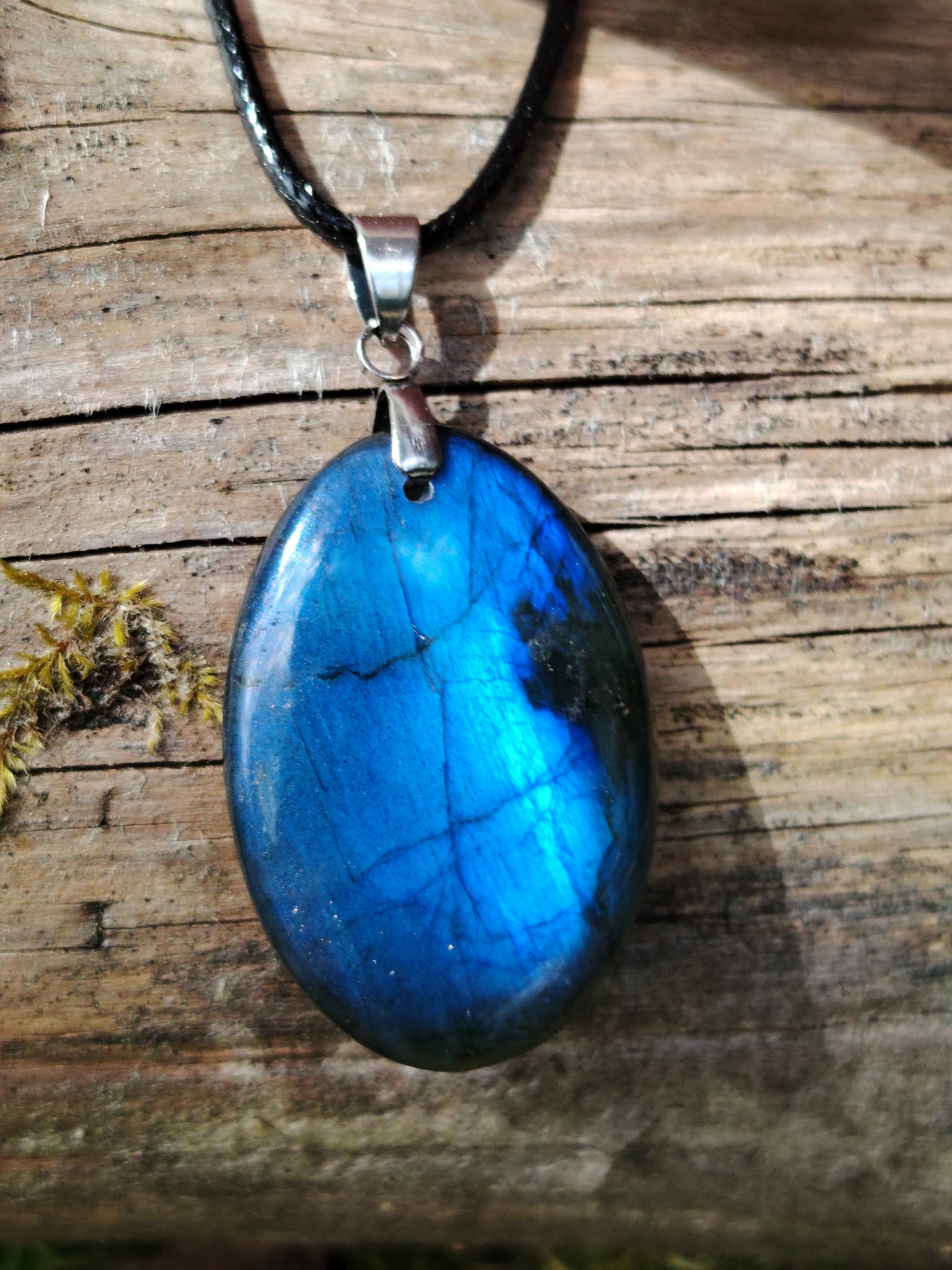Pendentif Labradorite bleue ovale sur bois naturel, reflet bleu intense, cordon noir et bélière argentée pour protection et intuition.