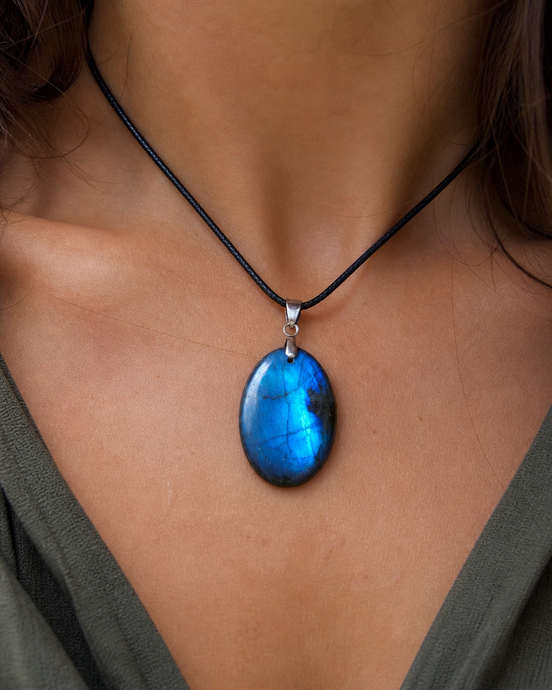 Pendentif Labradorite bleue porté sur cordon noir, pierre ovale aux reflets lumineux au creux du cou pour clarté et présence minérale.