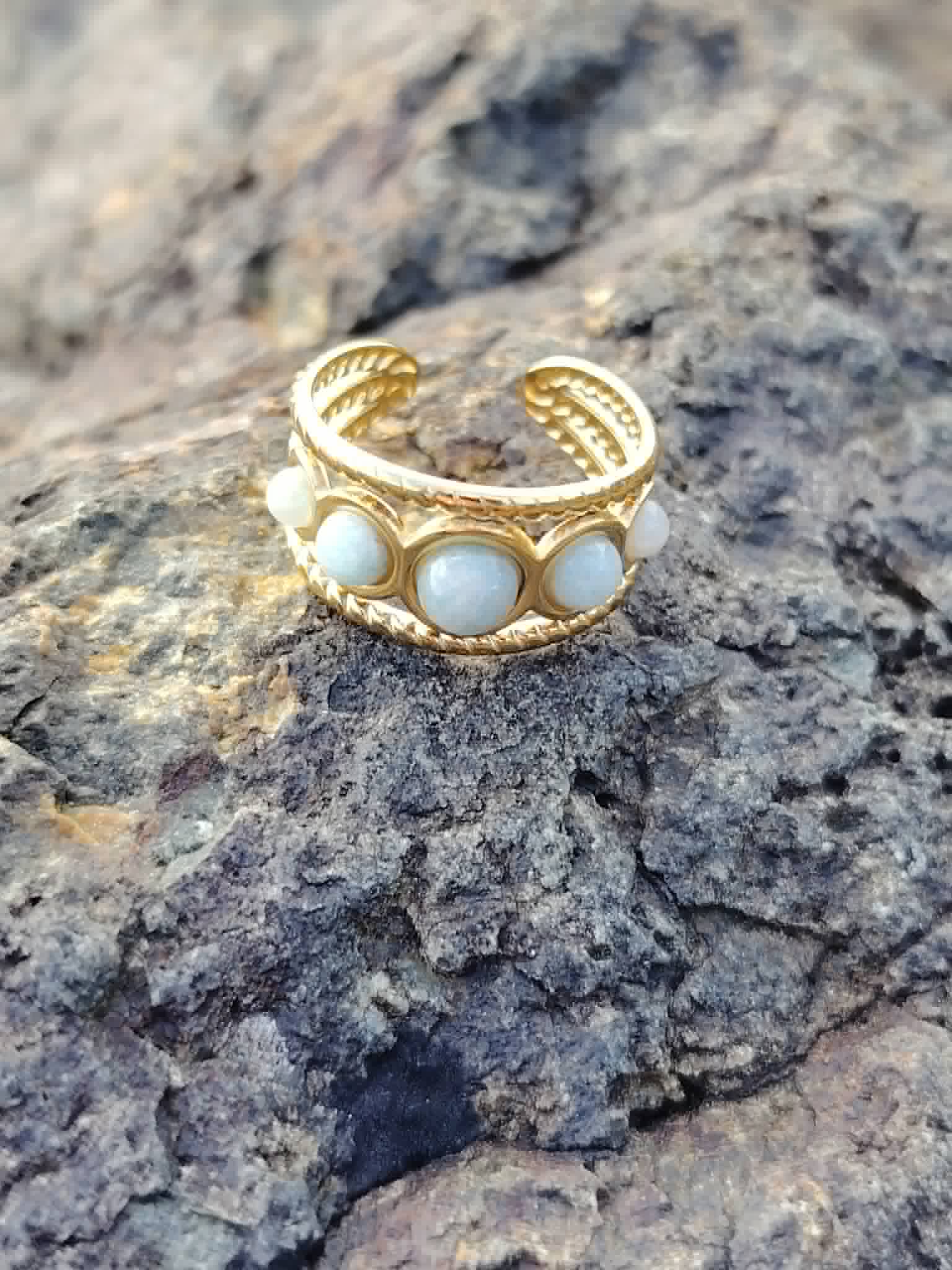 Bague Amazonite ajustable en acier inoxydable doré sur roche naturelle, cabochons clairs pour sérénité et expression sincère.