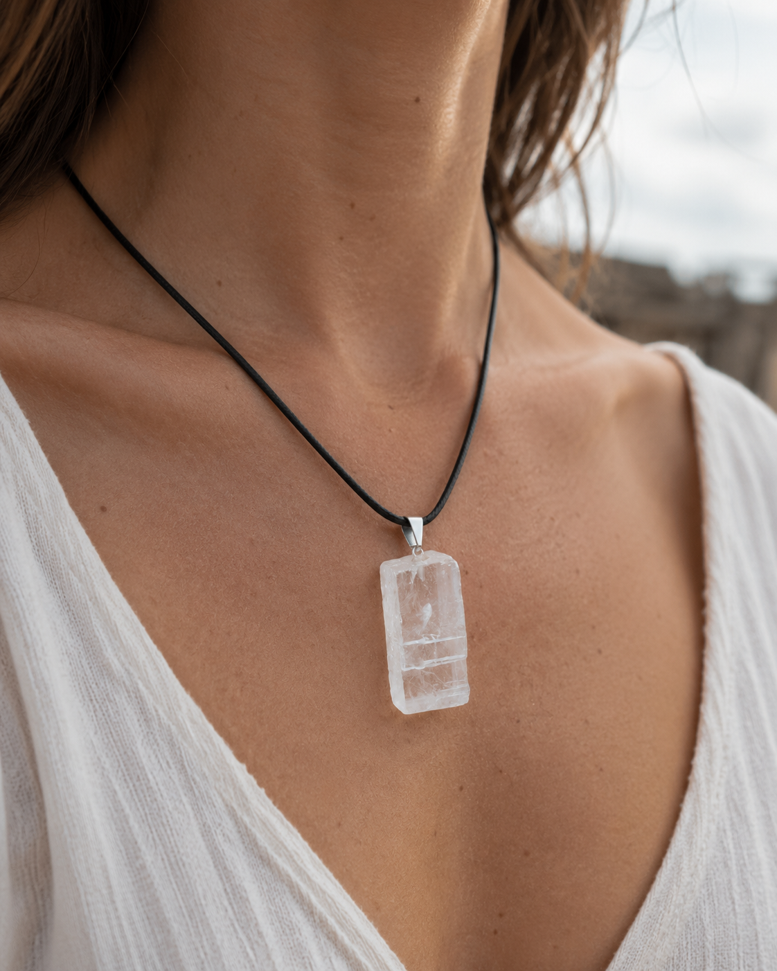 Pendentif Calcite Optique porté sur cordon noir avec haut blanc, pierre translucide au style minéral pour vision nuancée et présence douce.