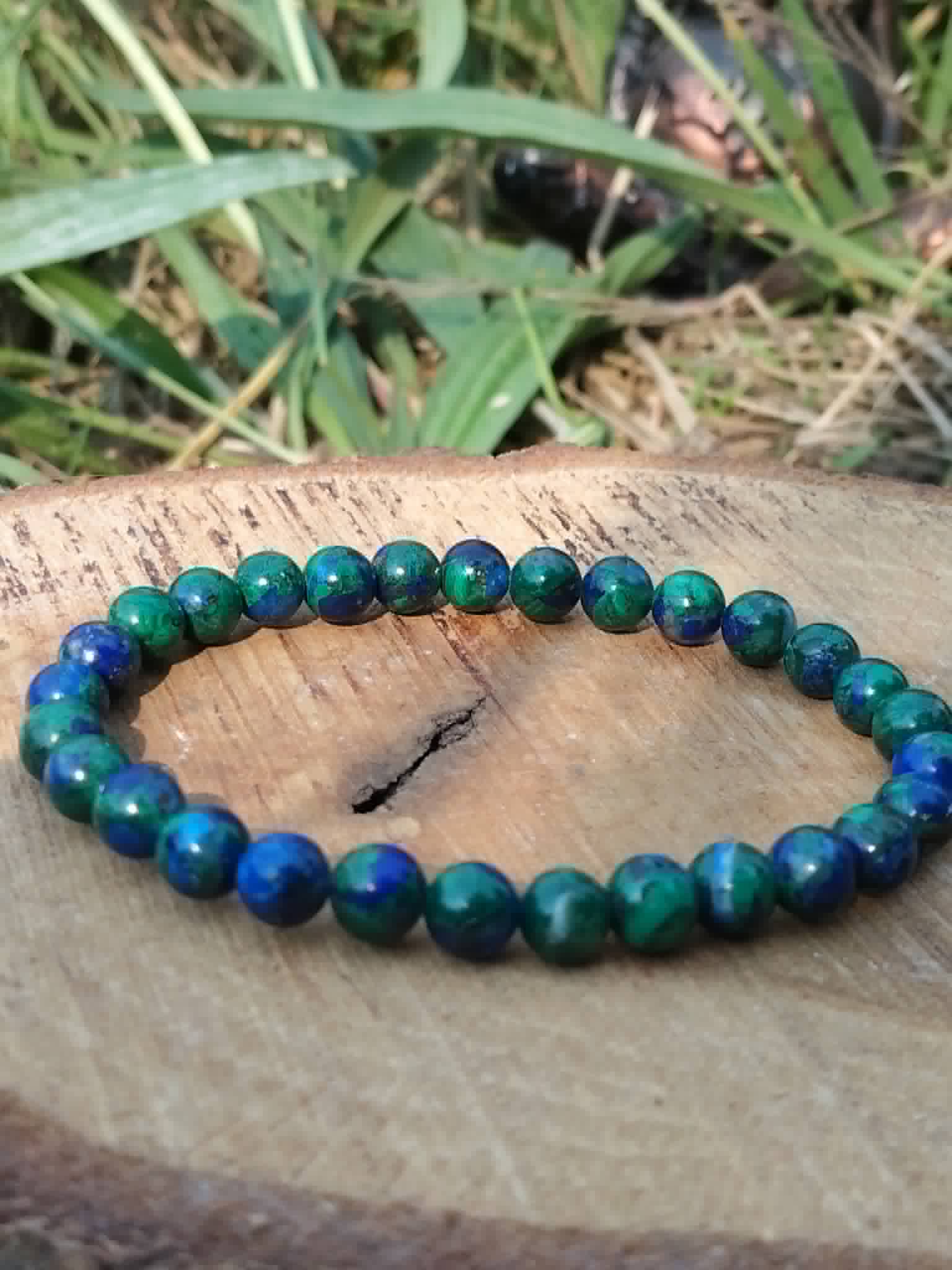 Bracelet Azurite-Malachite 6 mm posé sur tranche de bois, perles bleu profond et vertes, équilibre du cœur.