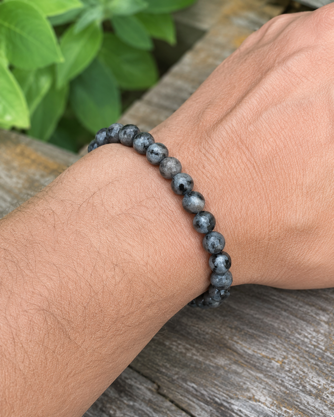 Bracelet Larvikite 8 mm porté au poignet sur fond clair, perles sombres naturelles, stabilité émotionnelle et patience.