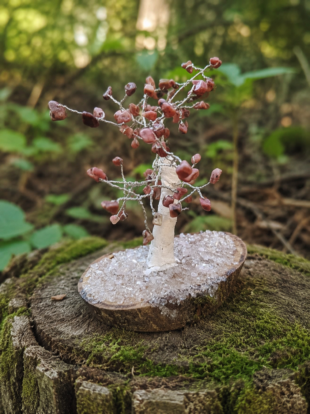 Petit arbre décoratif en Rhodonite baroque dans un décor naturel, lumière douce et énergie de compassion sans promesse miracle.