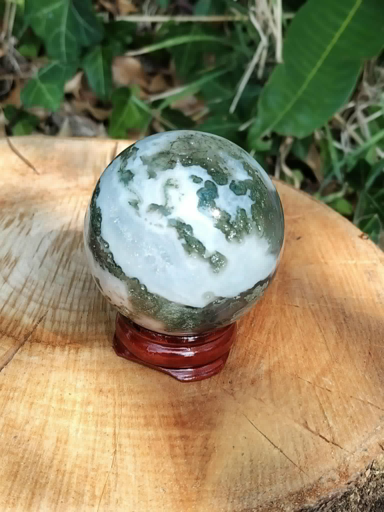 Sphère Agate Arbre sur support en bois, veinages mousseux visibles et présence naturelle pour espace bien-être.