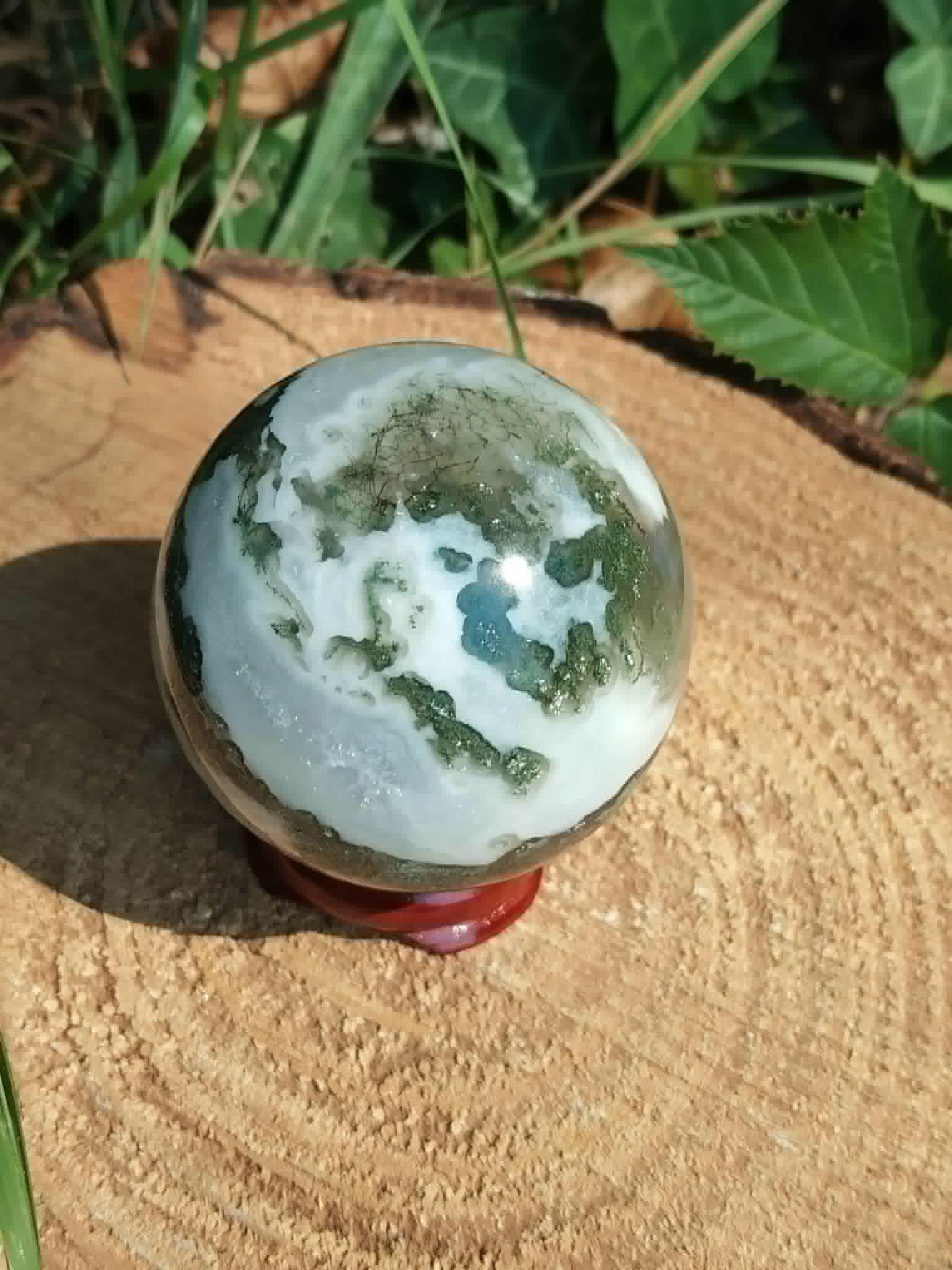 Sphère décorative en Agate Arbre sur bois clair, dessins végétaux uniques et stabilité émotionnelle.