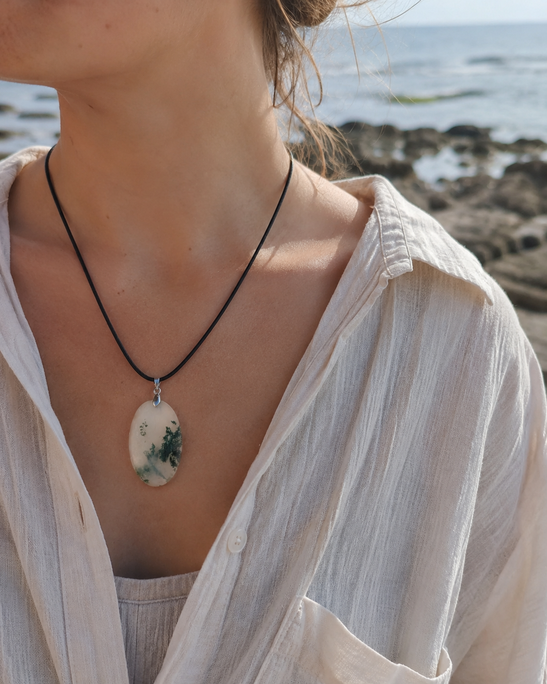 Pendentif Agate Mousse porté face à la mer en Bretagne, bijou ovale associé au calme et au retour à soi.