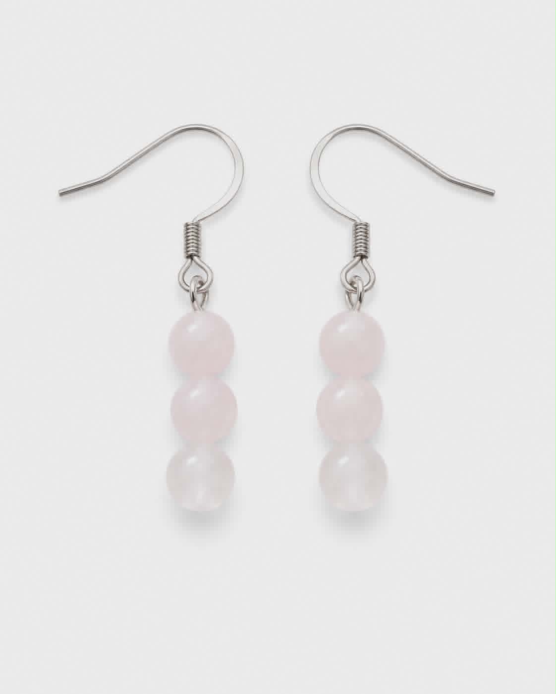 Boucles d’oreilles Quartz Rose sur fond blanc, perles rose pâle et crochets argentés, tendresse et amour de soi.