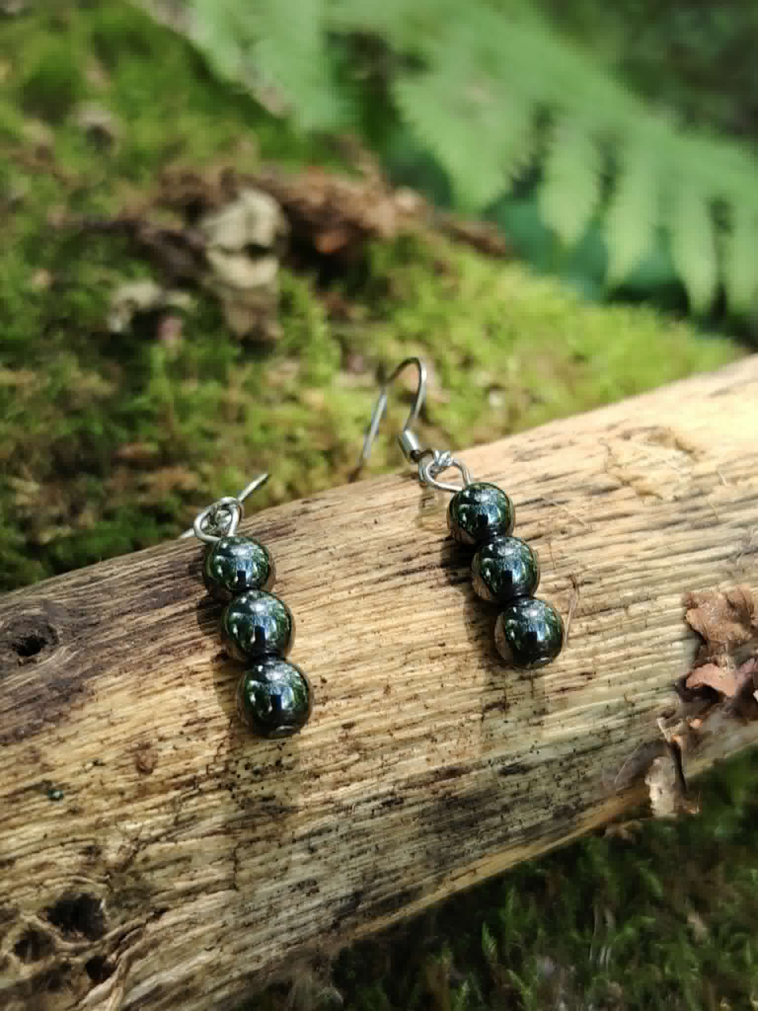 Boucles d’oreilles hématite création Magic Gaïa sur bois moussu, perles gris métallisé, protection énergétique symbolique.
