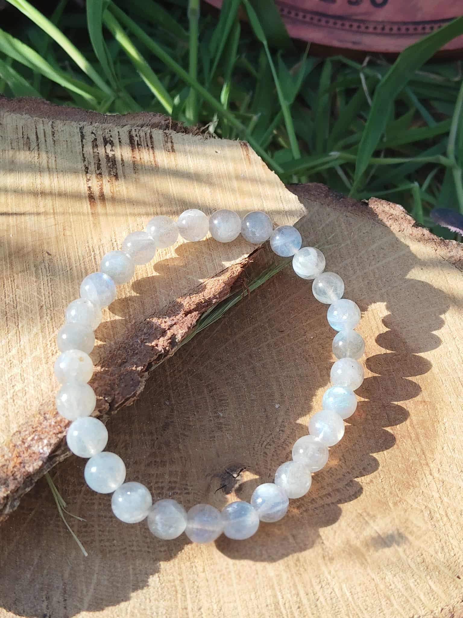 Bracelet labradorite irisée sur planche de bois, perles lumineuses en pierre naturelle, bouclier émotionnel et douceur