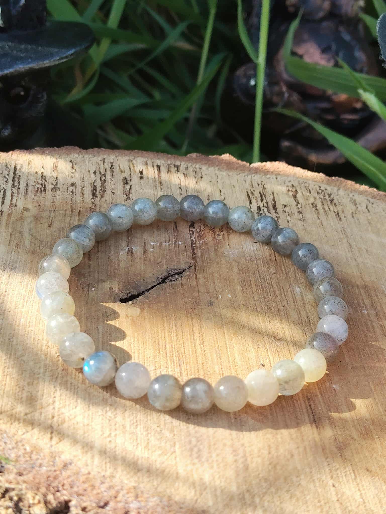 Bracelet labradorite 6 mm sur rondin de bois en décor naturel, perles grises aux reflets bleutés, protection et lucidité