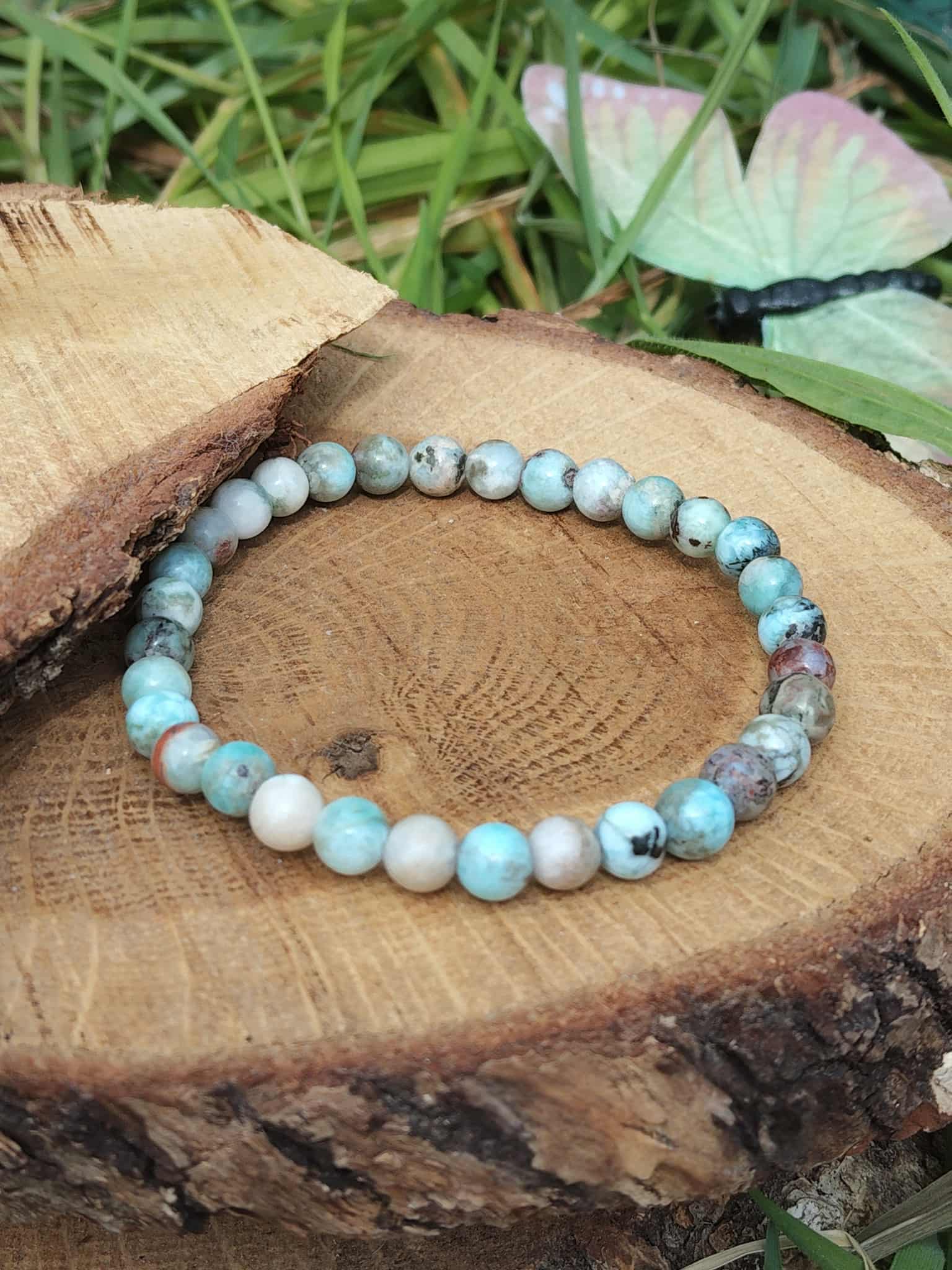 Bracelet larimar en perles naturelles sur rondin de bois avec papillon décoratif, bleu des Caraïbes et douceur émotionnelle