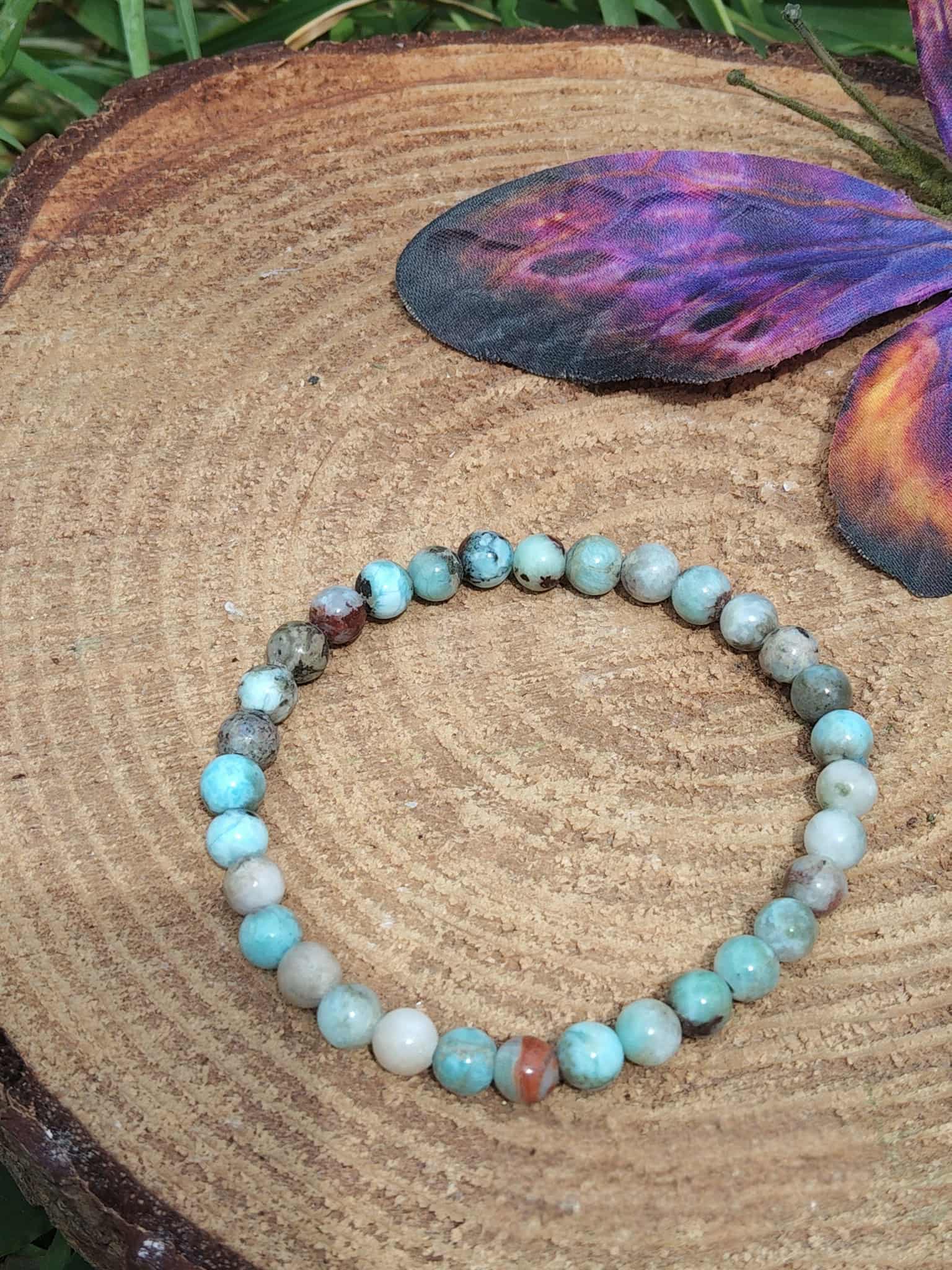 Bracelet larimar 6 mm sur bois en décor naturel, perles bleu turquoise, bleu pastel, blanc nuancé et inclusions brun gris, lâcher-prise, stabilité émotionnelle et sérénité