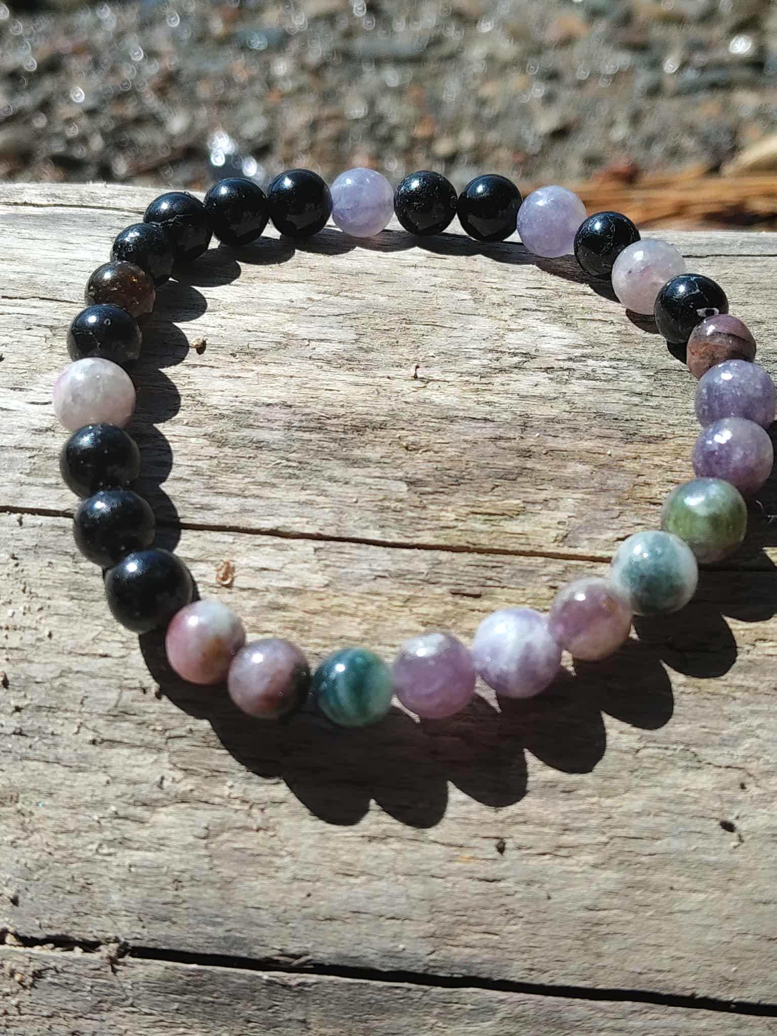 Bracelet tourmaline multicolore 6 mm sur planche de bois, bijou en pierres naturelles pour harmonisation émotionnelle et ancrage serein