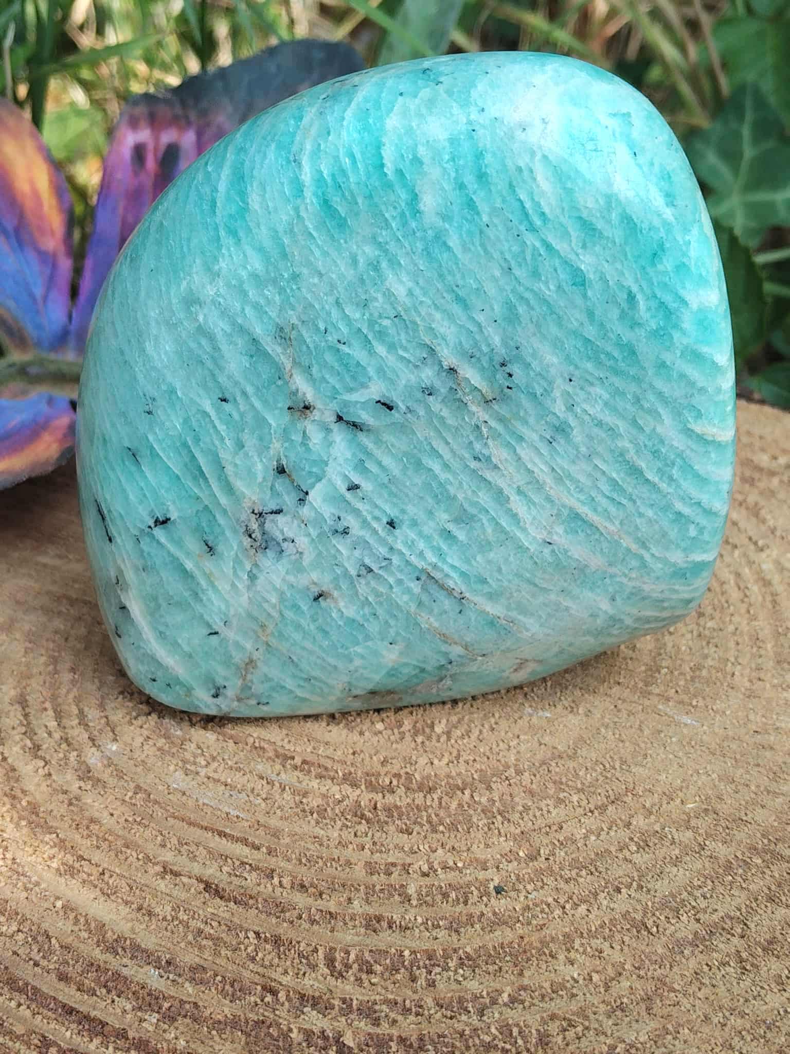 Amazonite polie posée sur plateau en bois rainuré, nuances lagon et détails minéraux mis en valeur en Bretagne.