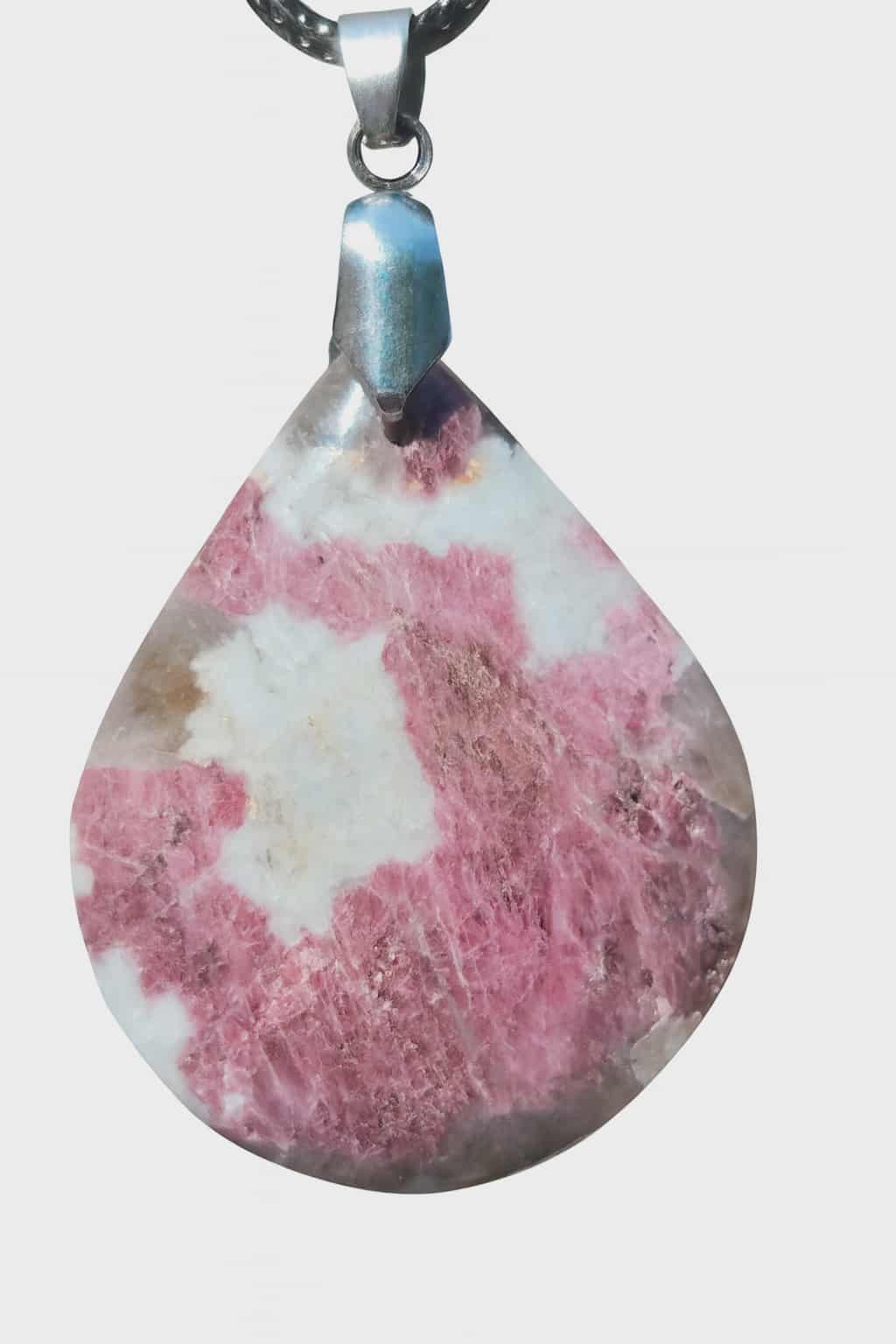 Pendentif goutte en tourmaline rose à surface polie brillante sur fond blanc, bijou en pierre naturelle relié à la douceur intérieure, à l’apaisement et à la sensibilité du cœur.