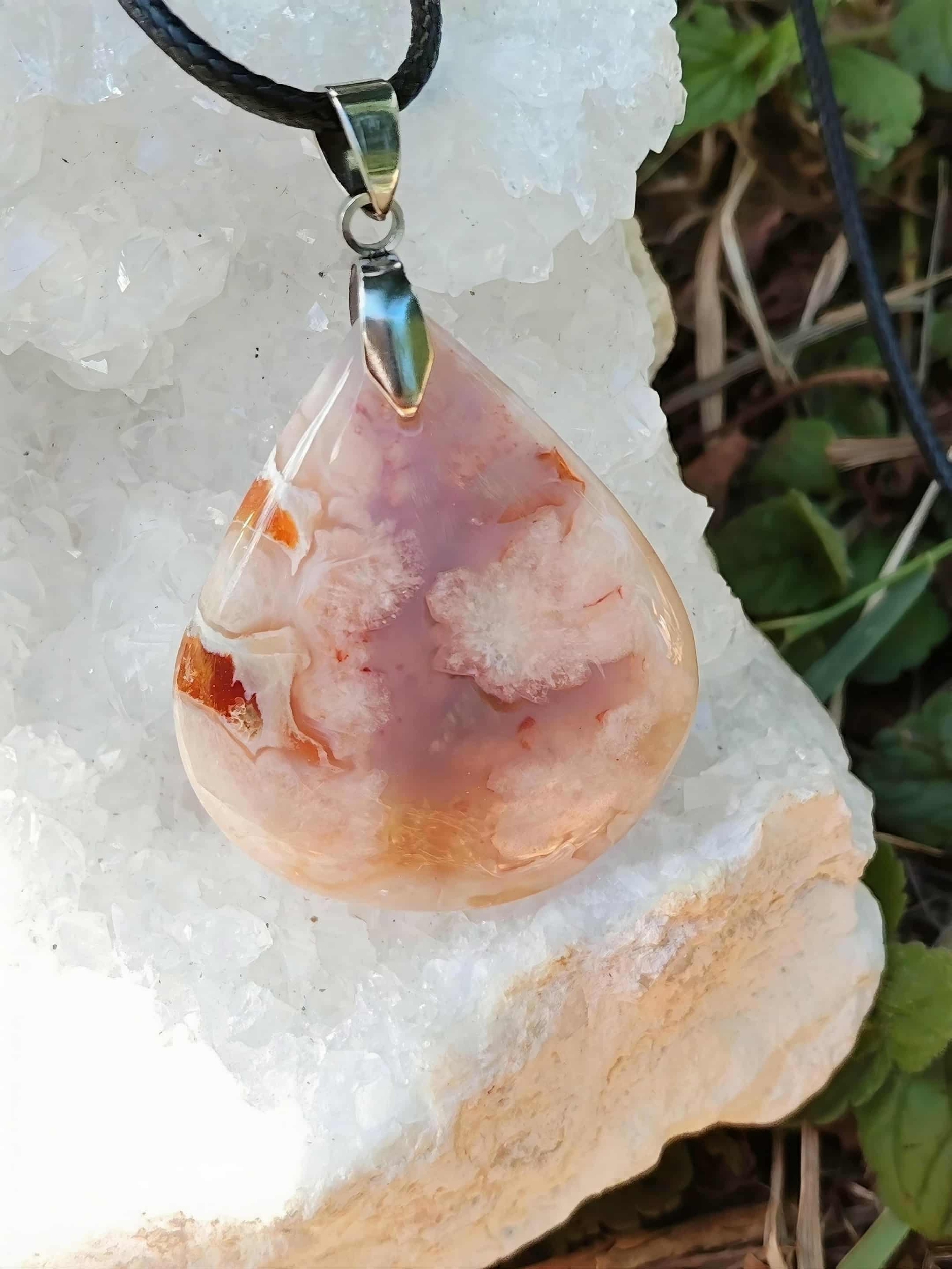 Pendentif goutte agate fleur de cerisier sur géode blanche, cordon noir – reflets chauds, évoque joie, optimisme, confiance.