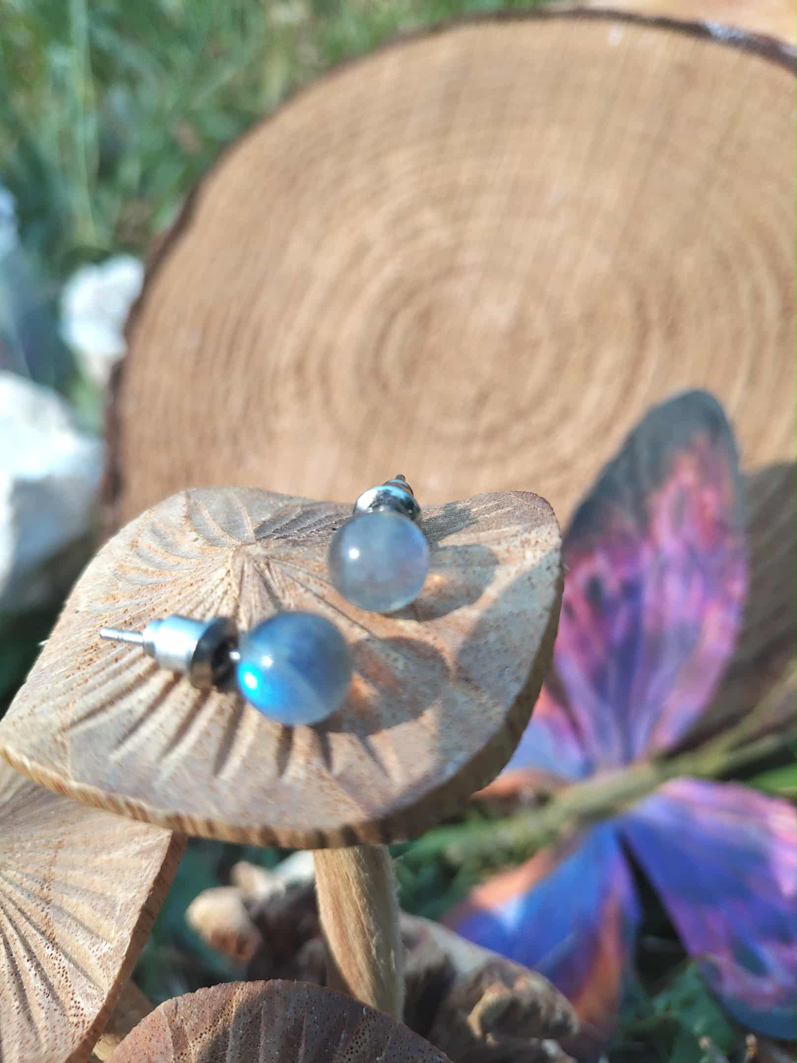 Clous d’oreilles en labradorite – inox 304 – présentés sur un décor papillon de bois et papillon coloré ; reflets bleutés.