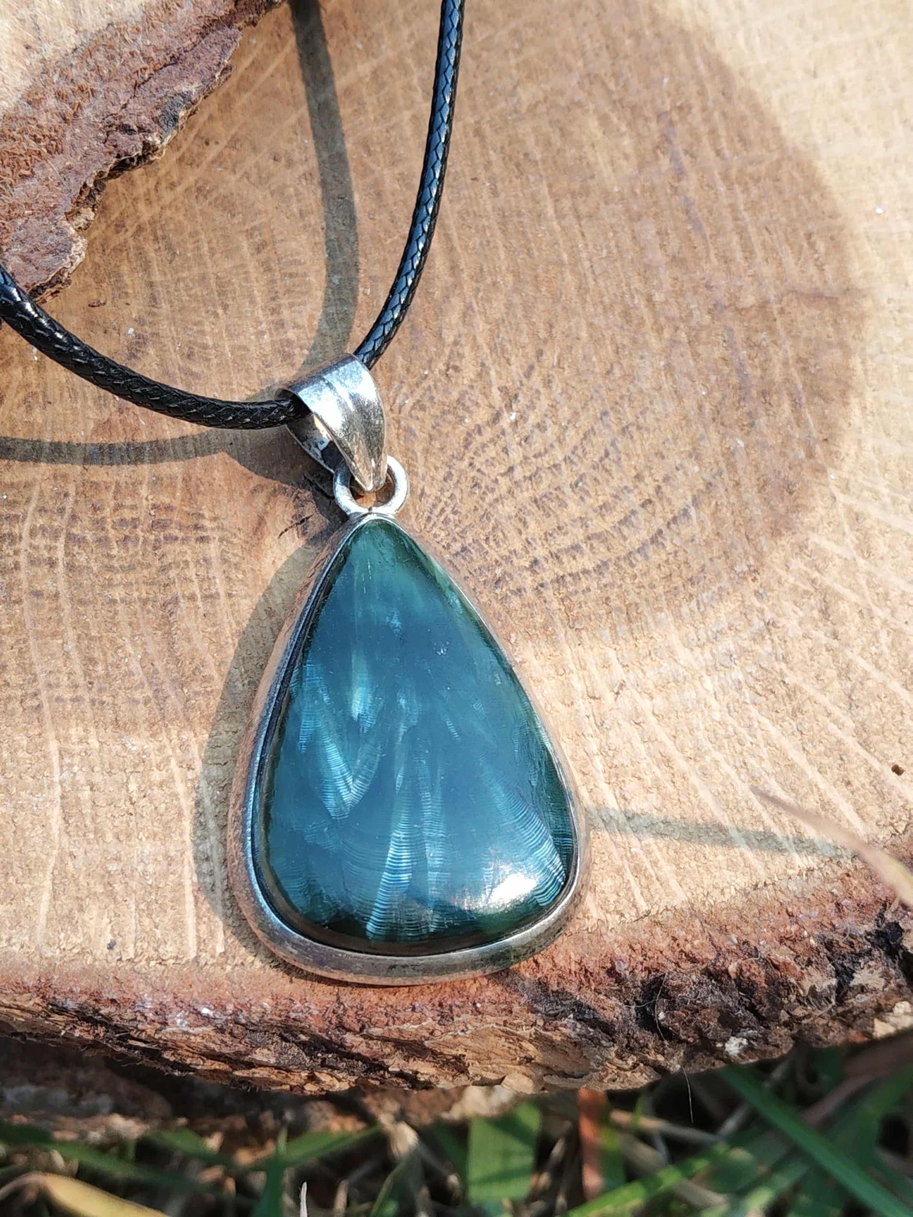 Gros plan sur pendentif en séraphinite avec argent 925, reflets soyeux vert argenté, bijou en pierre naturelle évoquant l’apaisement, la tendresse intérieure et la stabilité émotionnelle.