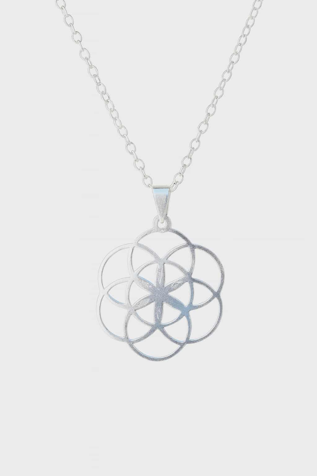 Pendentif graine de vie en argent 925 sur fond blanc, gros plan sur chaîne fine et symbole de géométrie sacrée