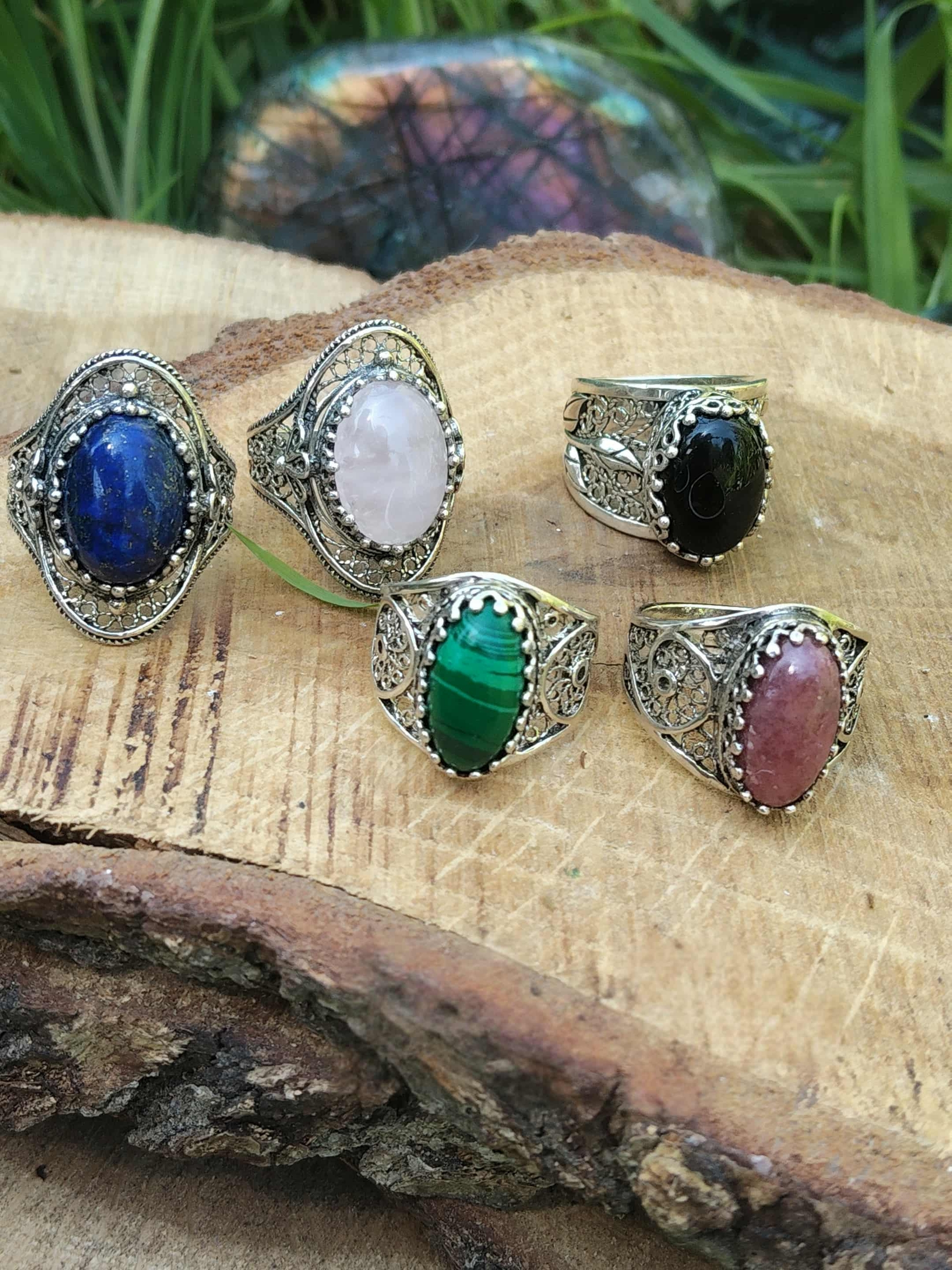 Variantes de bagues cabochon en argent 925 : Malachite, Lapis-Lazuli, Quartz Rose, Onyx, Rhodonite, présentées sur support en bois