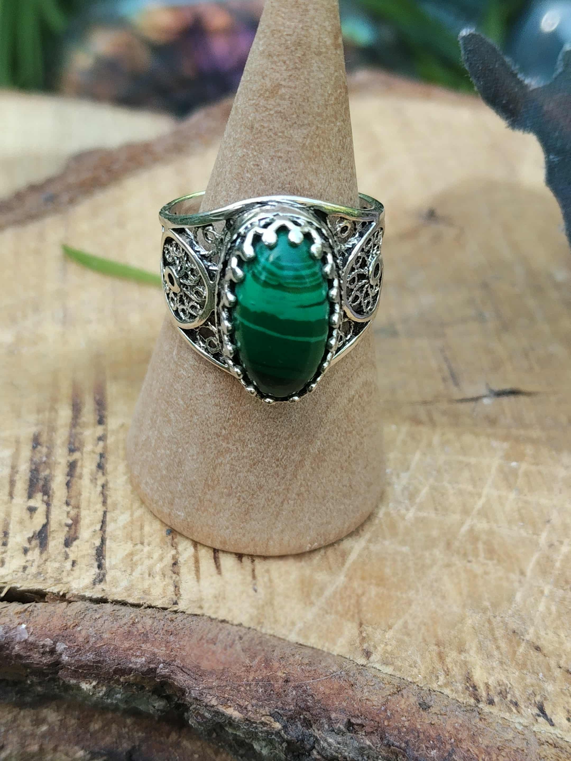 Bague en argent 925 filigrané avec cabochon de malachite, présentée sur cône en bois – ouverture du cœur et ancrage (lithothérapie)
