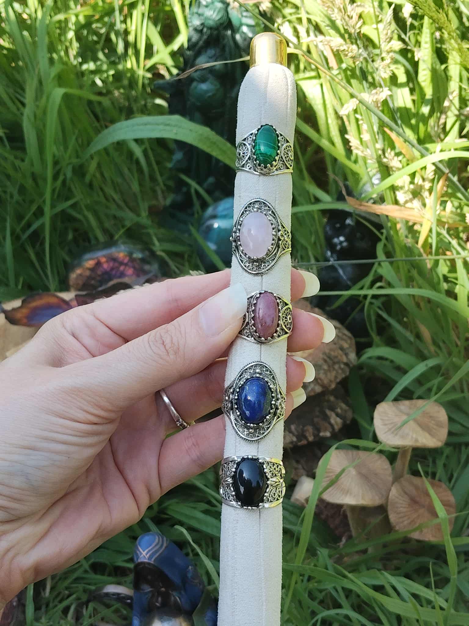 Présentoir avec bagues cabochon en argent 925 (Malachite, Quartz Rose, Rhodonite, Lapis-Lazuli, Onyx), montures filigranées, photo en extérieur