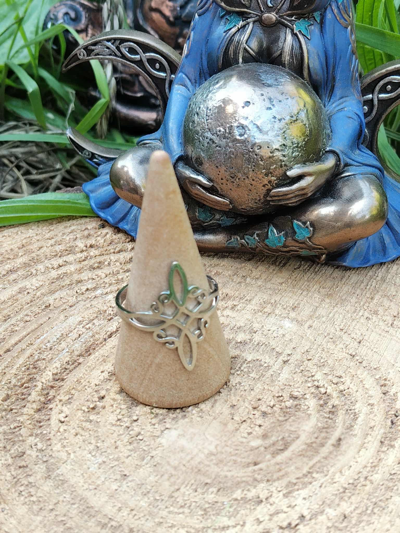 Bague nœud de sorcière réglable en acier inoxydable sur cône, statue d’Hécate en arrière-plan