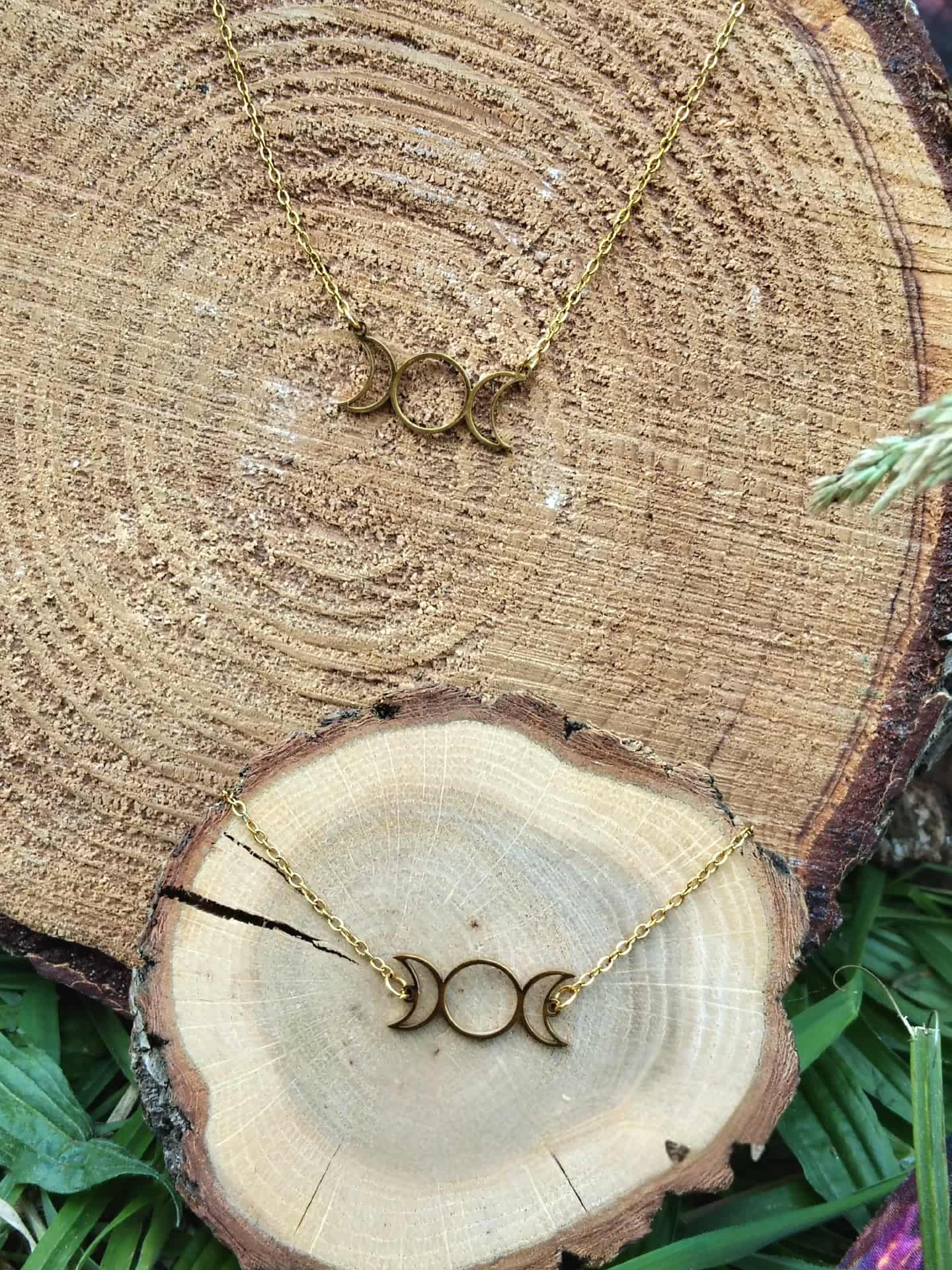 Set bijou Triple Lune doré avec pendentif et bracelet, acier inoxydable sur fond bois et feuillage, esprit mystique