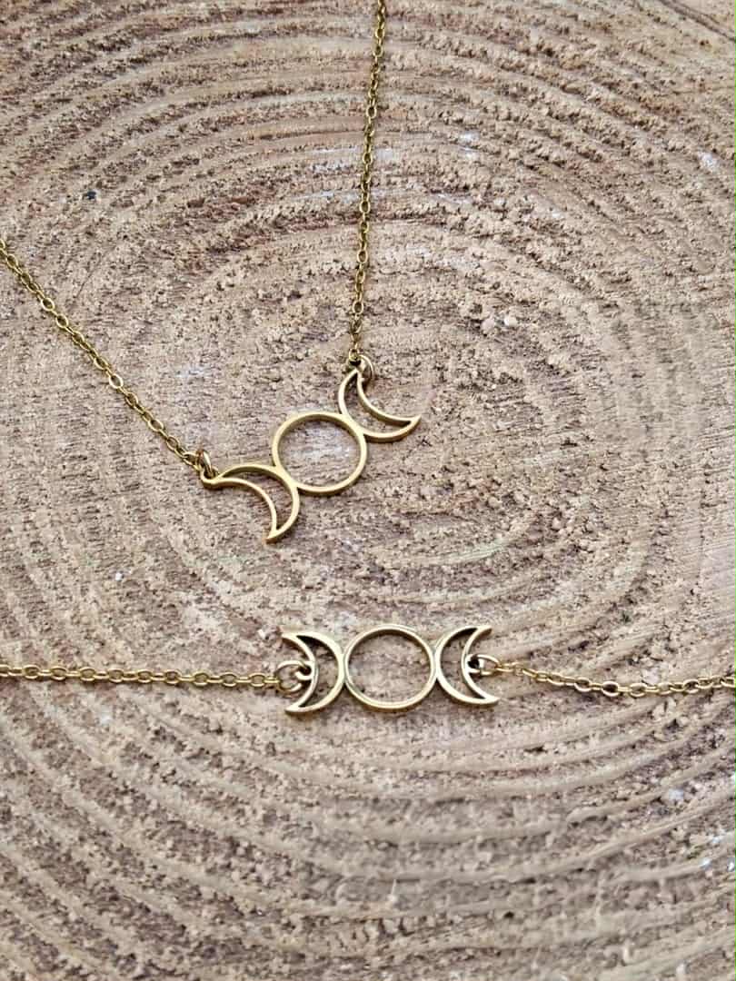 Pendentif et bracelet Triple Lune dorés en acier inoxydable sur bois naturel, duo de bijoux lunaires fins et symboliques